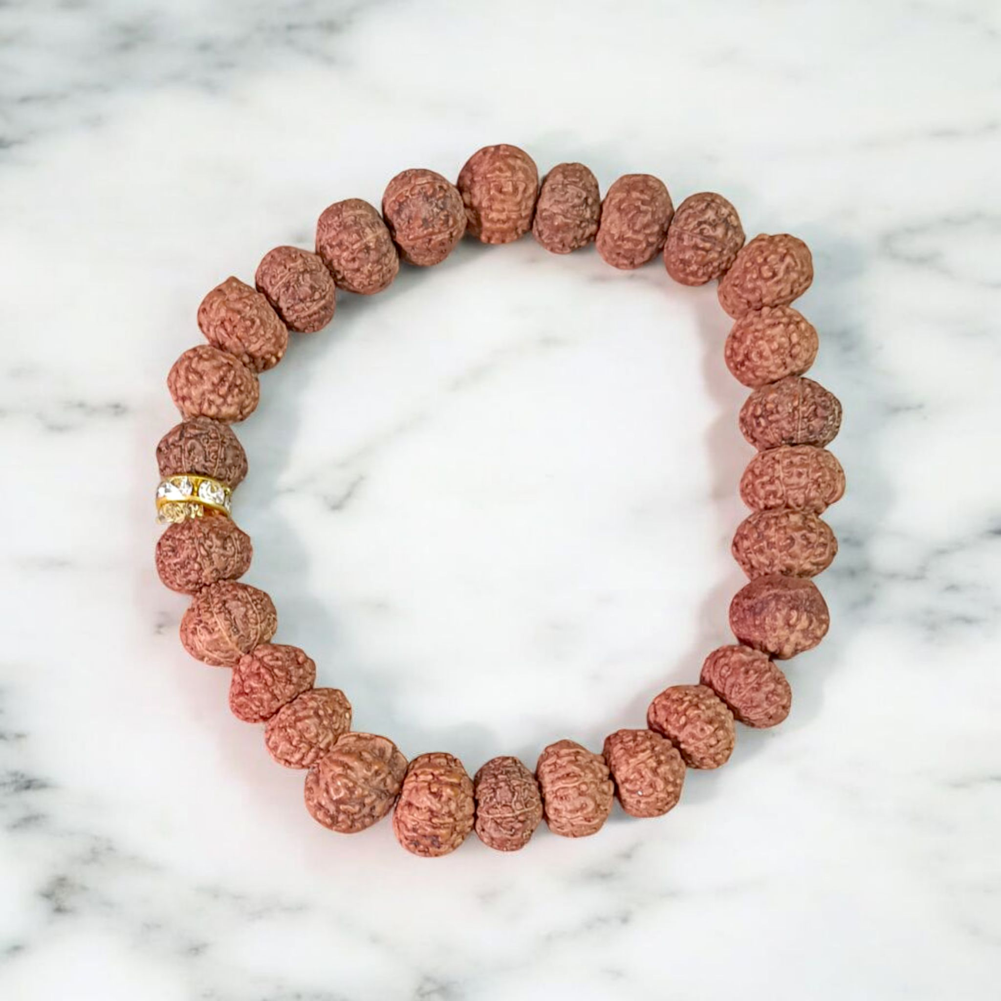Image of 7 Mukhi Rudraksha Bracelet with 9mm natural brown beads, arranged in a stretchable circular form, set against a neutral background