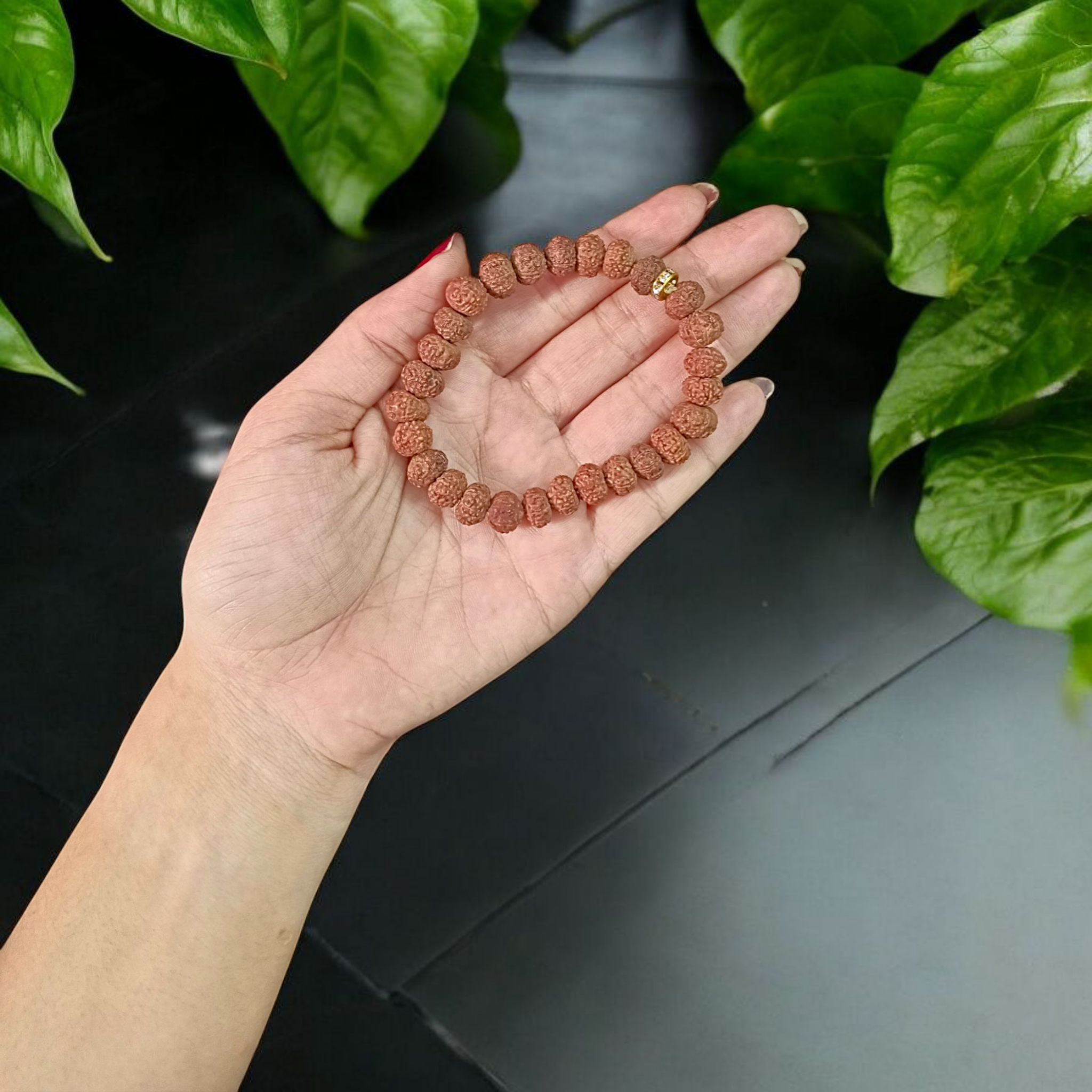 Image of 7 Mukhi Rudraksha Bracelet with 9mm natural brown beads, arranged in a stretchable circular form, set against a neutral background