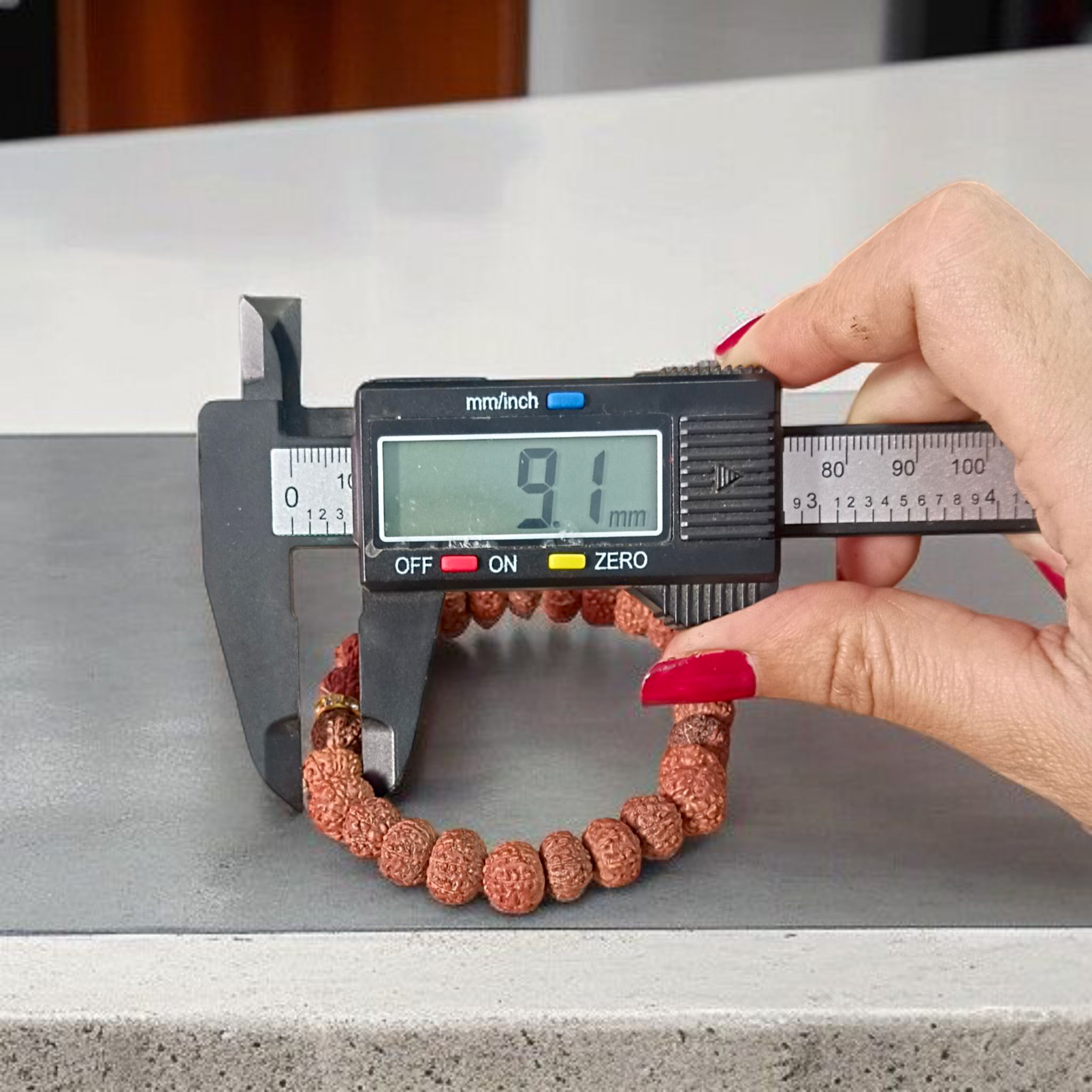 Image of 7 Mukhi Rudraksha Bracelet with 9mm natural brown beads, arranged in a stretchable circular form, set against a neutral background