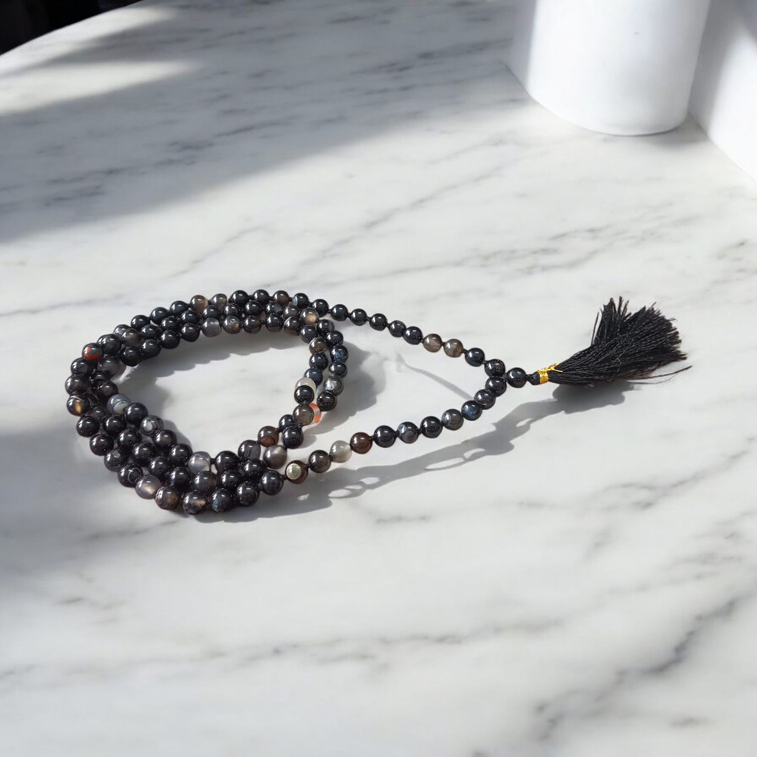 Image of Natural Sulemani Hakik Mala (Black Agate) with 8MM smooth round beads, available in 108+1 and 27+1 configurations, used for meditation and daily wear