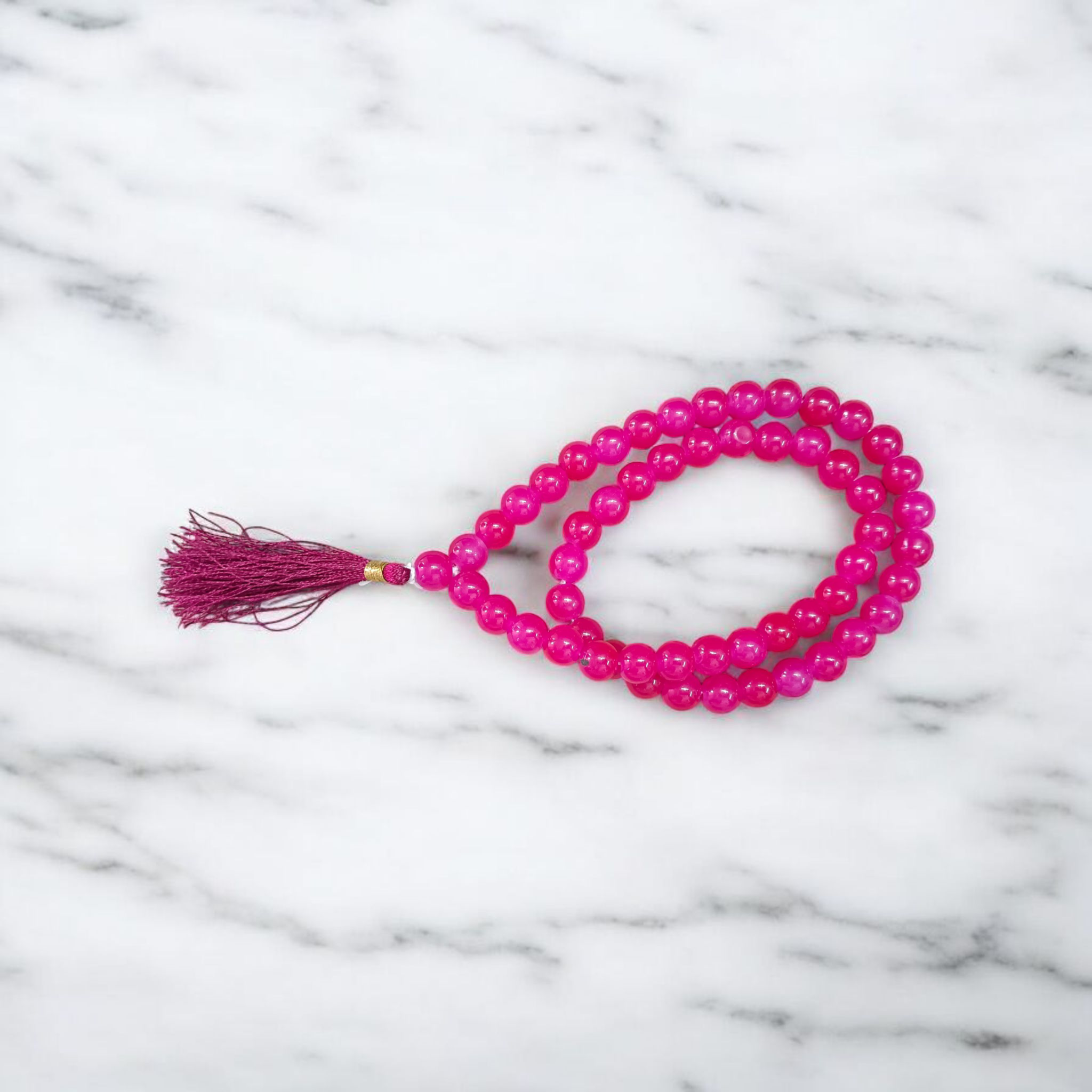 Image of Pink Agate Mala with 54+1 polished 8mm pink beads, ideal for mantra chanting, emotional healing, and meditation, displayed on a neutral background