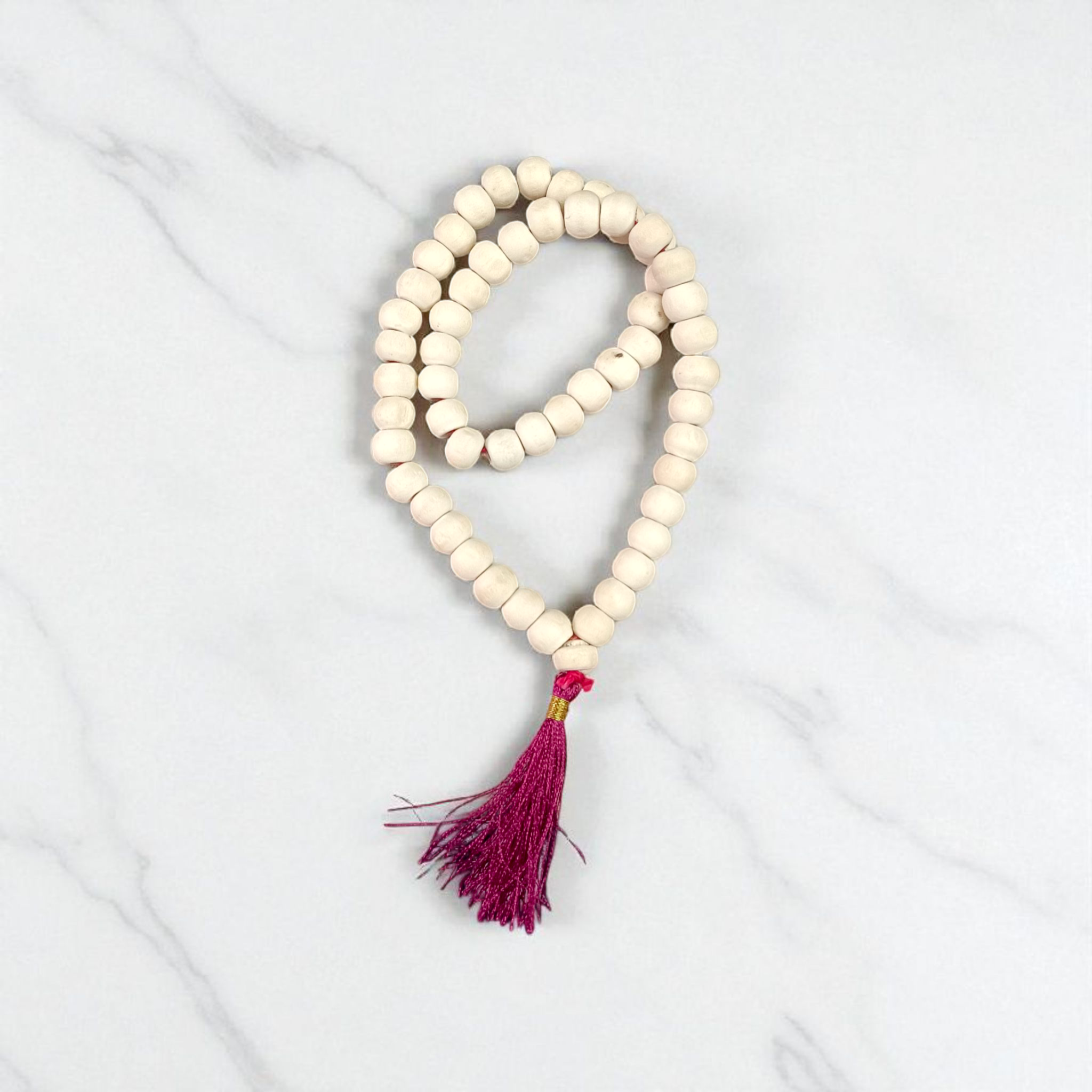 Image of a handcrafted Natural Tulsi Mala with 54+1 beads, 8mm size, laid neatly on a wooden surface with a spiritual setting background