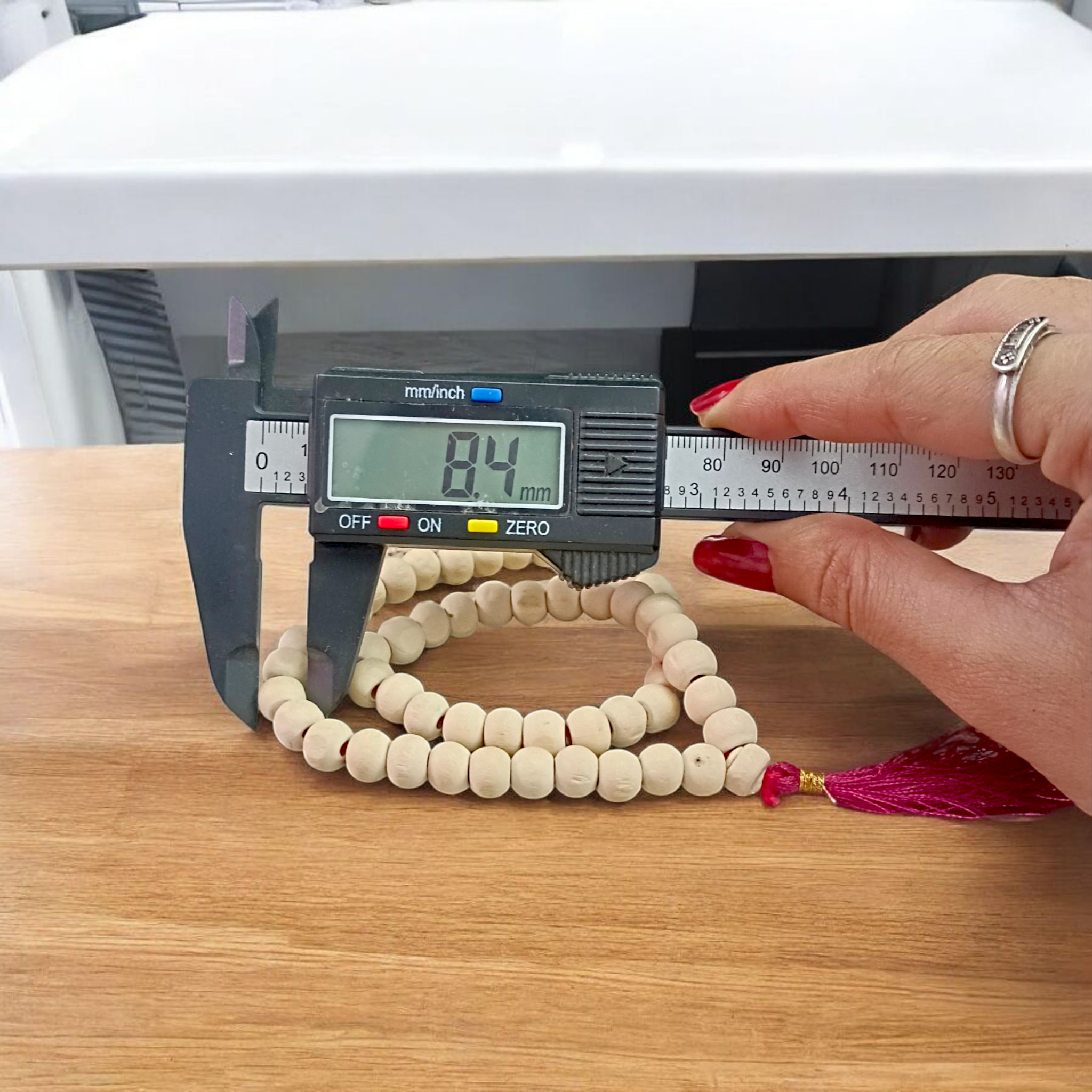 Image of a handcrafted Natural Tulsi Mala with 54+1 beads, 8mm size, laid neatly on a wooden surface with a spiritual setting background