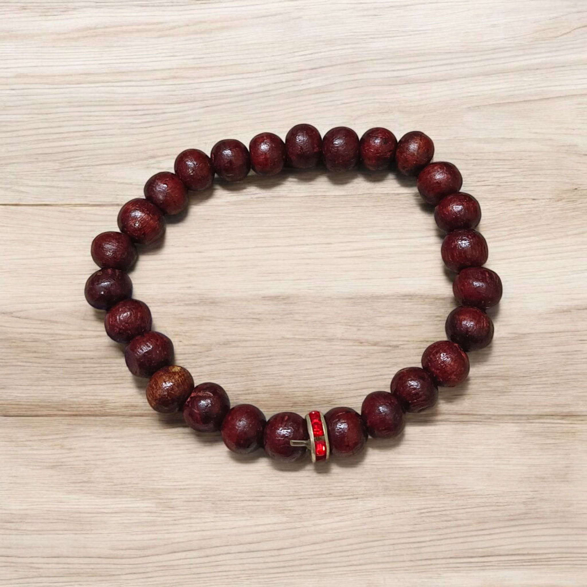 Image of a stretchable bracelet made with 8mm natural red sandalwood (Lal Chandan) beads, neatly arranged on a flat neutral background