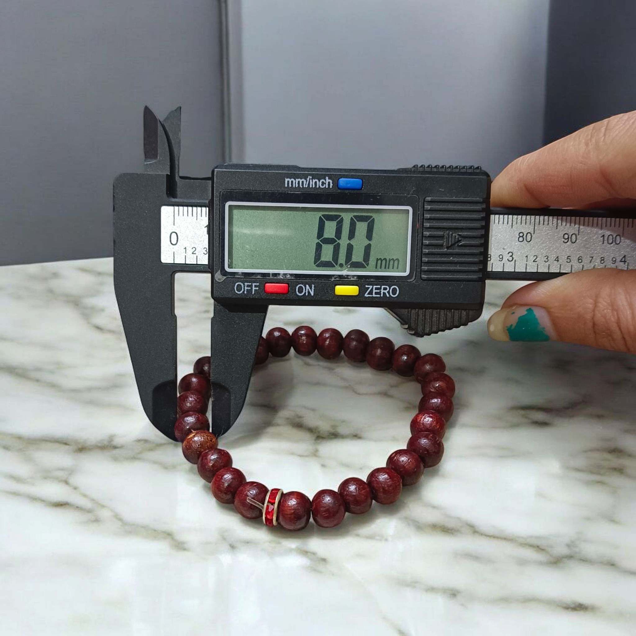 Image of a stretchable bracelet made with 8mm natural red sandalwood (Lal Chandan) beads, neatly arranged on a flat neutral background