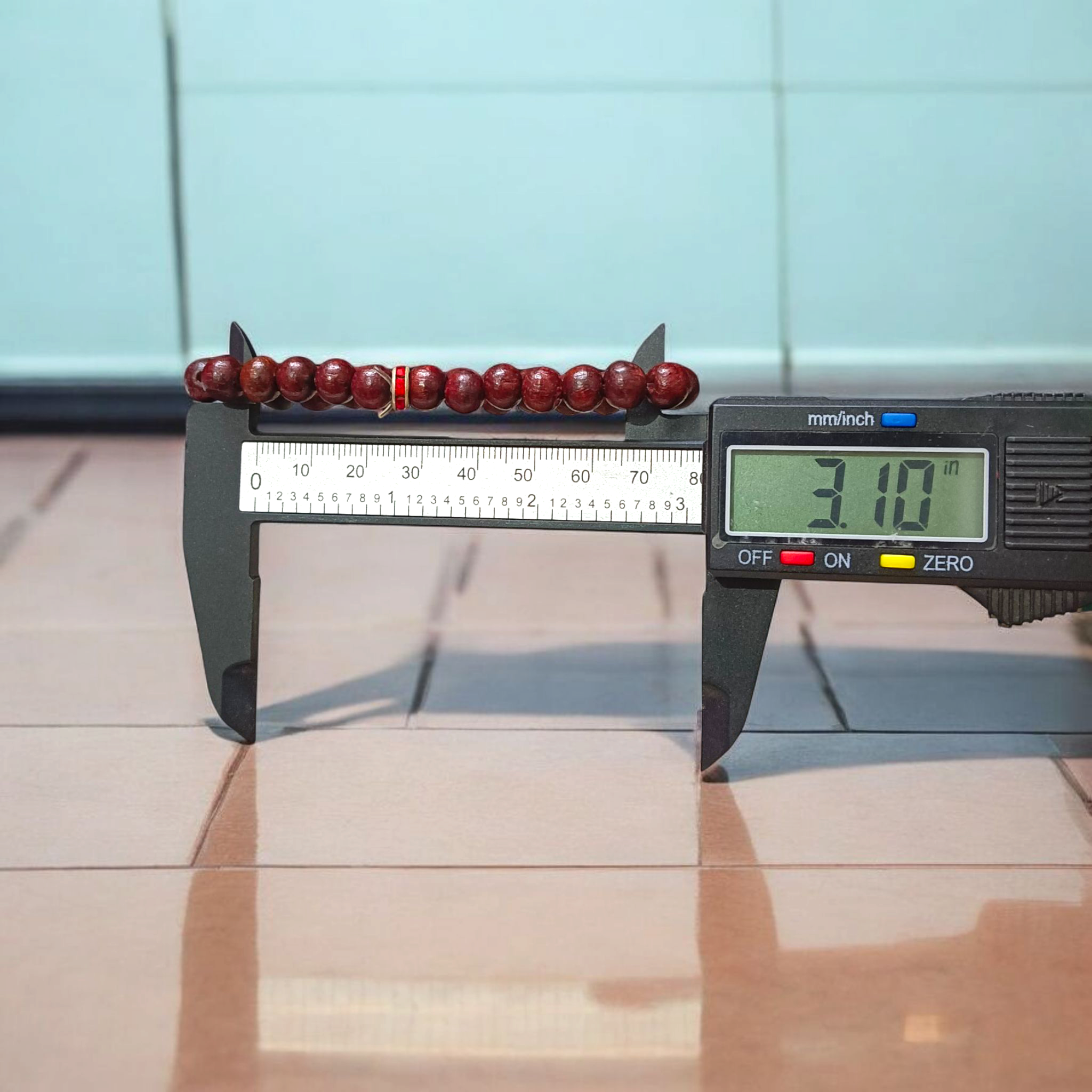 Image of a stretchable bracelet made with 8mm natural red sandalwood (Lal Chandan) beads, neatly arranged on a flat neutral background