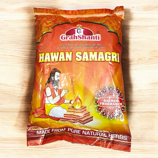 Image showing a 500GM pack of Hawan Samagri containing colorful natural herbs and powders used for Vedic rituals, placed beside puja essentials