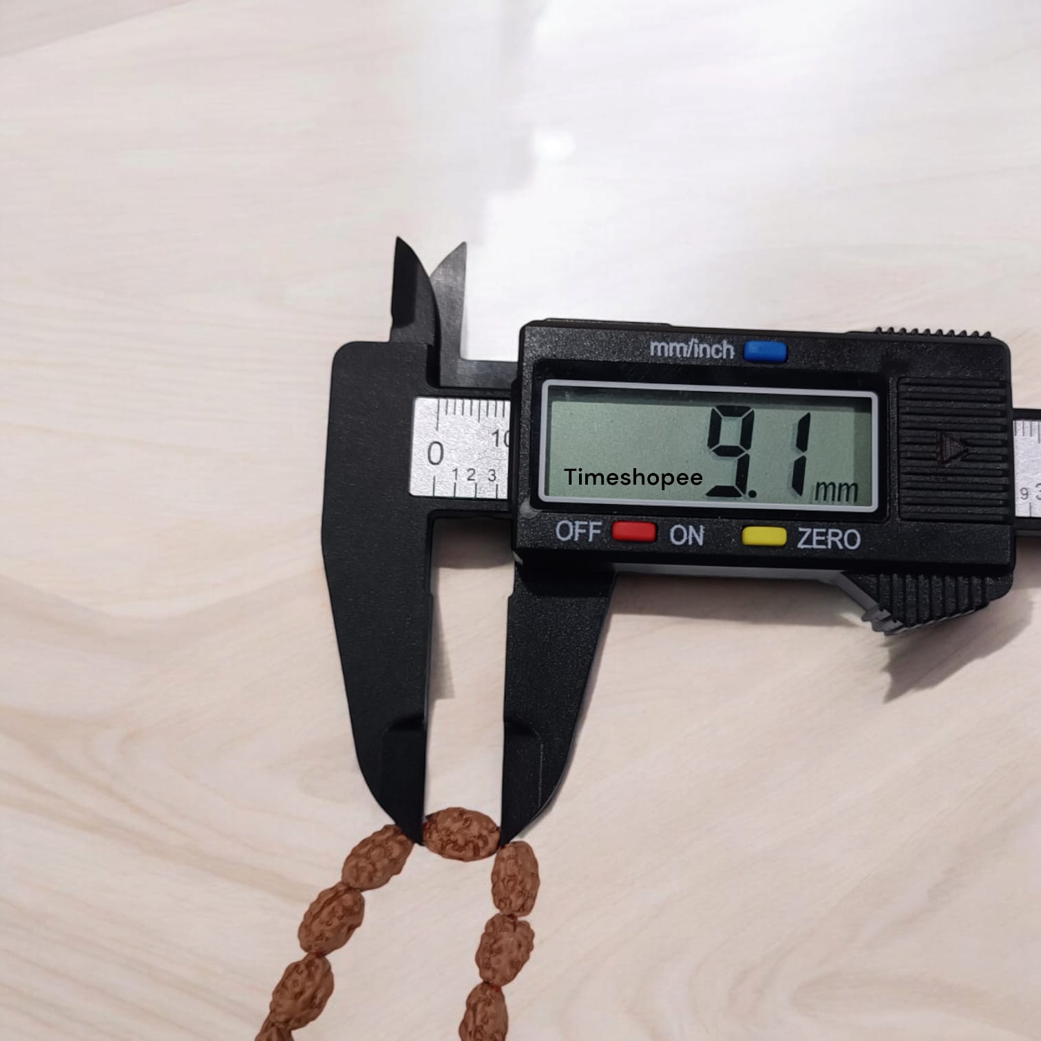 Image showing a hand-crafted 2 Mukhi Rudraksha Mala in 108+1 bead variant, lab certified and neatly arranged on a traditional cloth background with Timeshopee tag