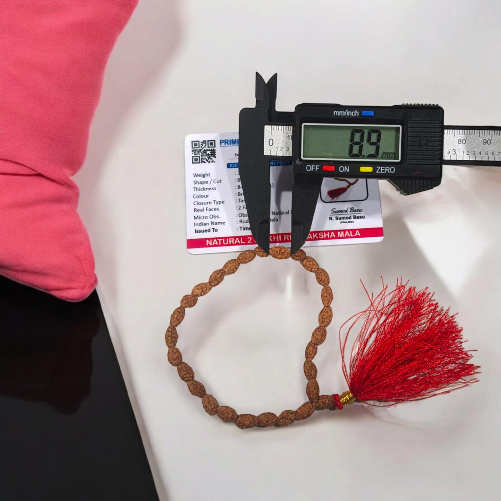 Image showing a hand-crafted 2 Mukhi Rudraksha Mala in 108+1 bead variant, lab certified and neatly arranged on a traditional cloth background with Timeshopee tag.