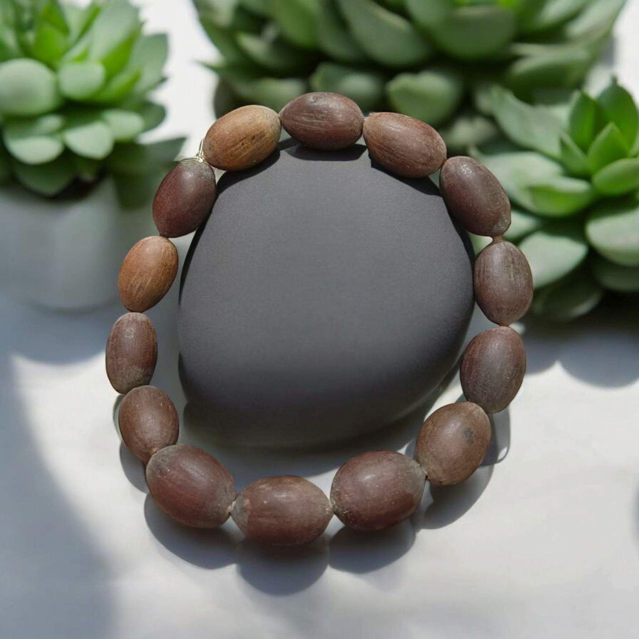 Image showing a handcrafted Kamal Gutta Bracelet made from 100% original lotus seeds, placed on a spiritual background with natural light.