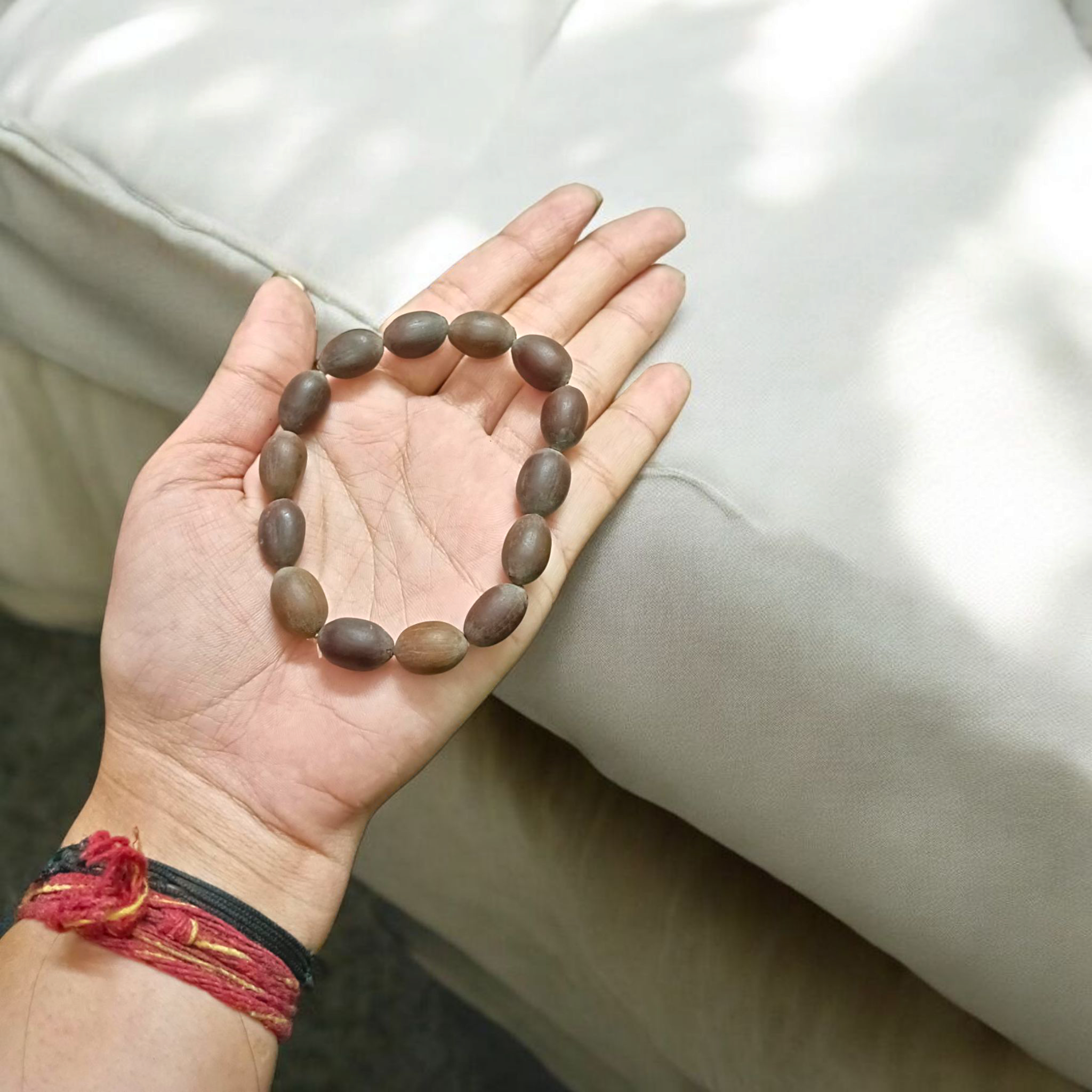 Image showing a handcrafted Kamal Gutta Bracelet made from 100% original lotus seeds, placed on a spiritual background with natural light.