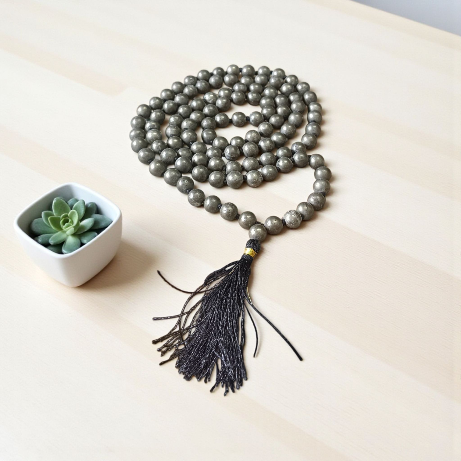 Lab-certified Natural Raw Pyrite Mala (108+1 beads, 8MM) with metallic golden finish, placed on a white background with spiritual packaging