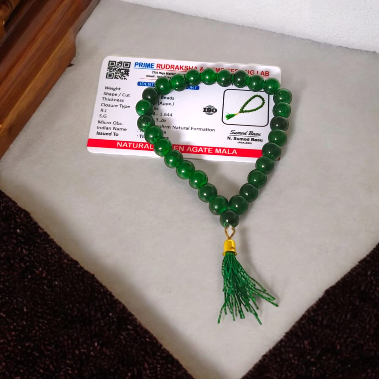 A 27+1 bead green agate mala, each bead measuring 8mm, shown with its lab certification. Ideal for meditation, wearing, or placement in car and office.