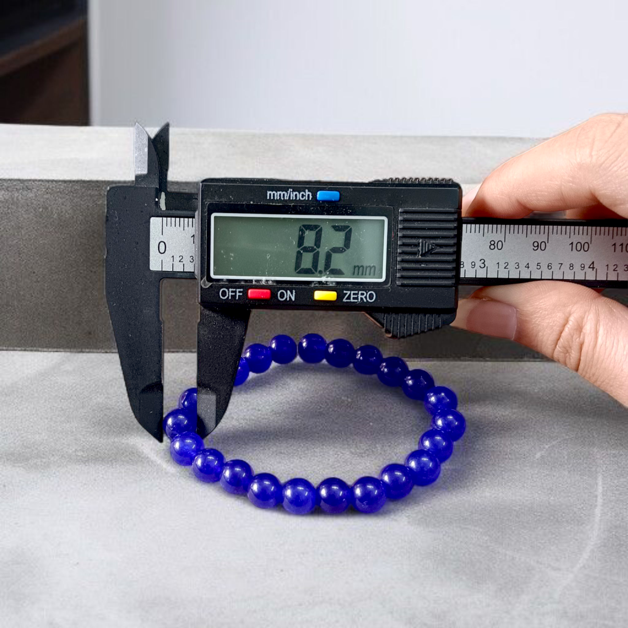 Natural Blue Agate (Hakik) Bracelet with 8mm round beads on a stretchable elastic cord, displayed in hand for spiritual and daily wear