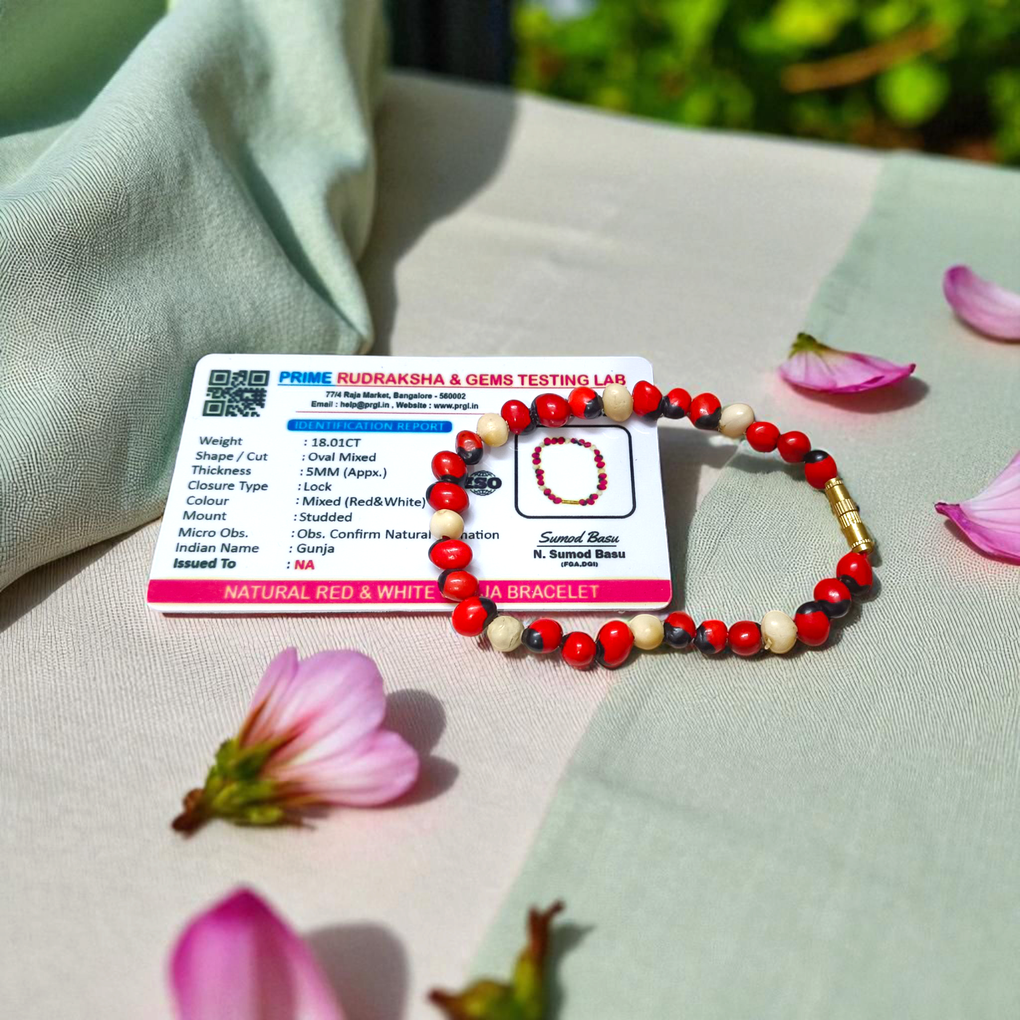 Natural Red and White Gunja seed bracelet with 5mm stretchable beads, spiritual design laid on a neutral background