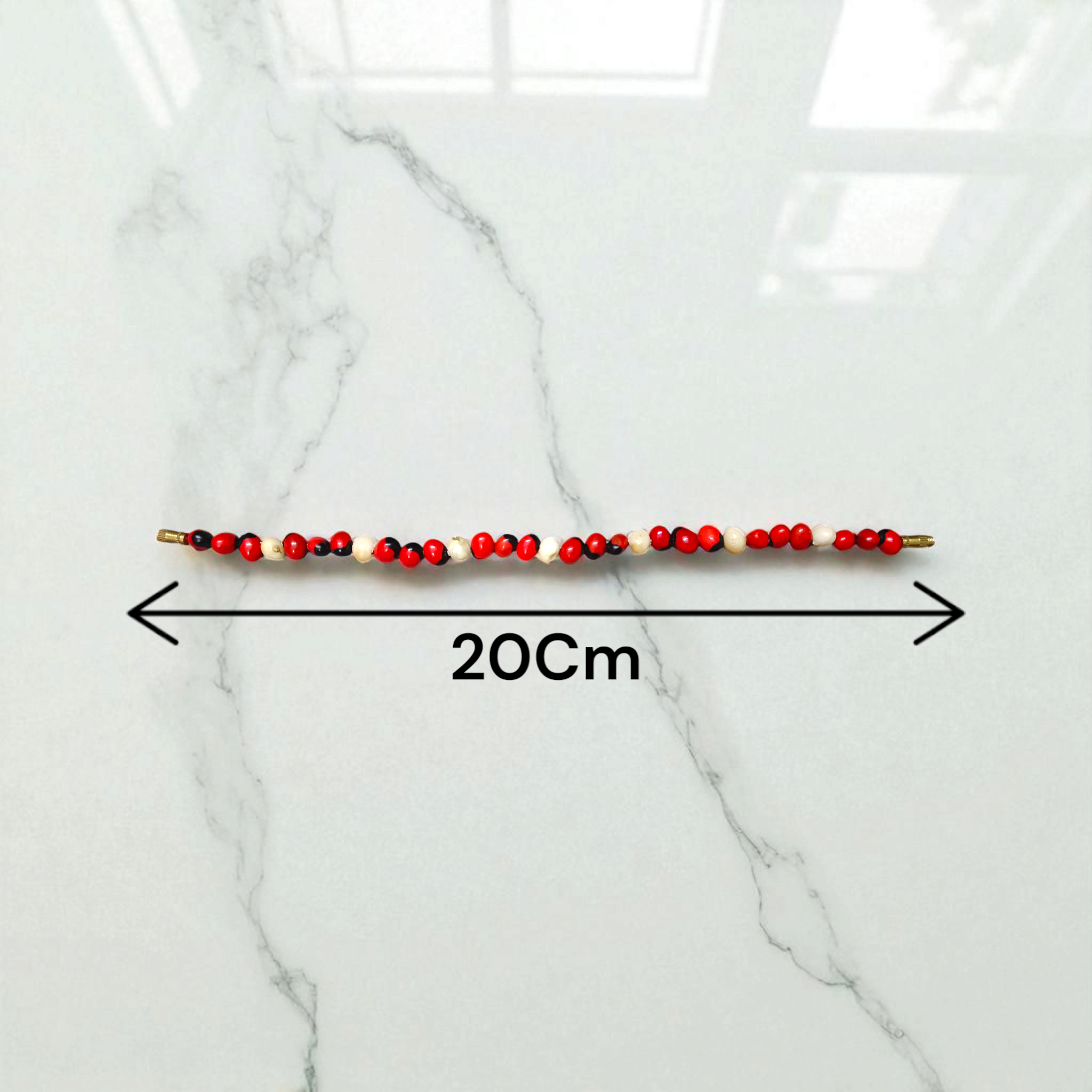 Natural Red and White Gunja seed bracelet with 5mm stretchable beads, spiritual design laid on a neutral background