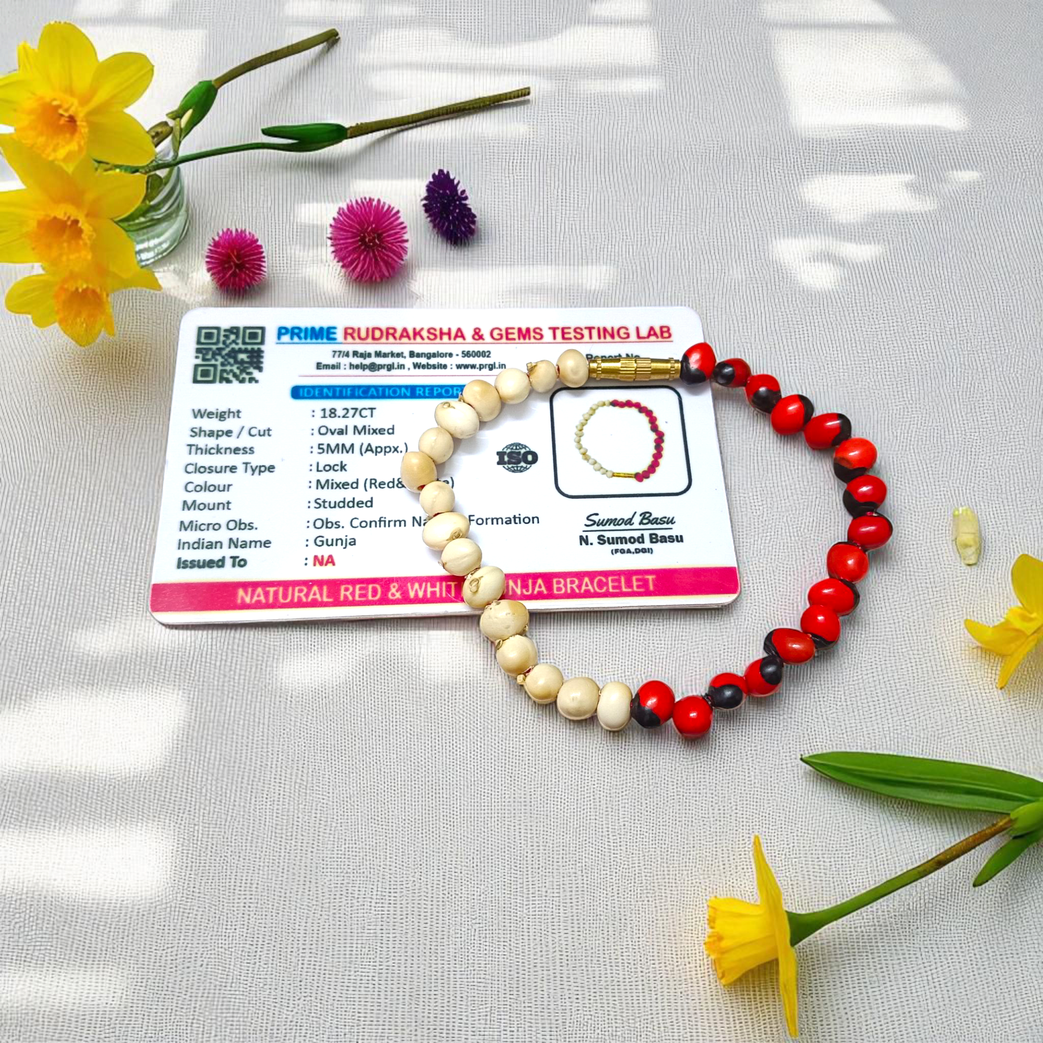 Natural Red and White Gunja seed bracelet with 5mm stretchable beads, spiritual design laid on a neutral background