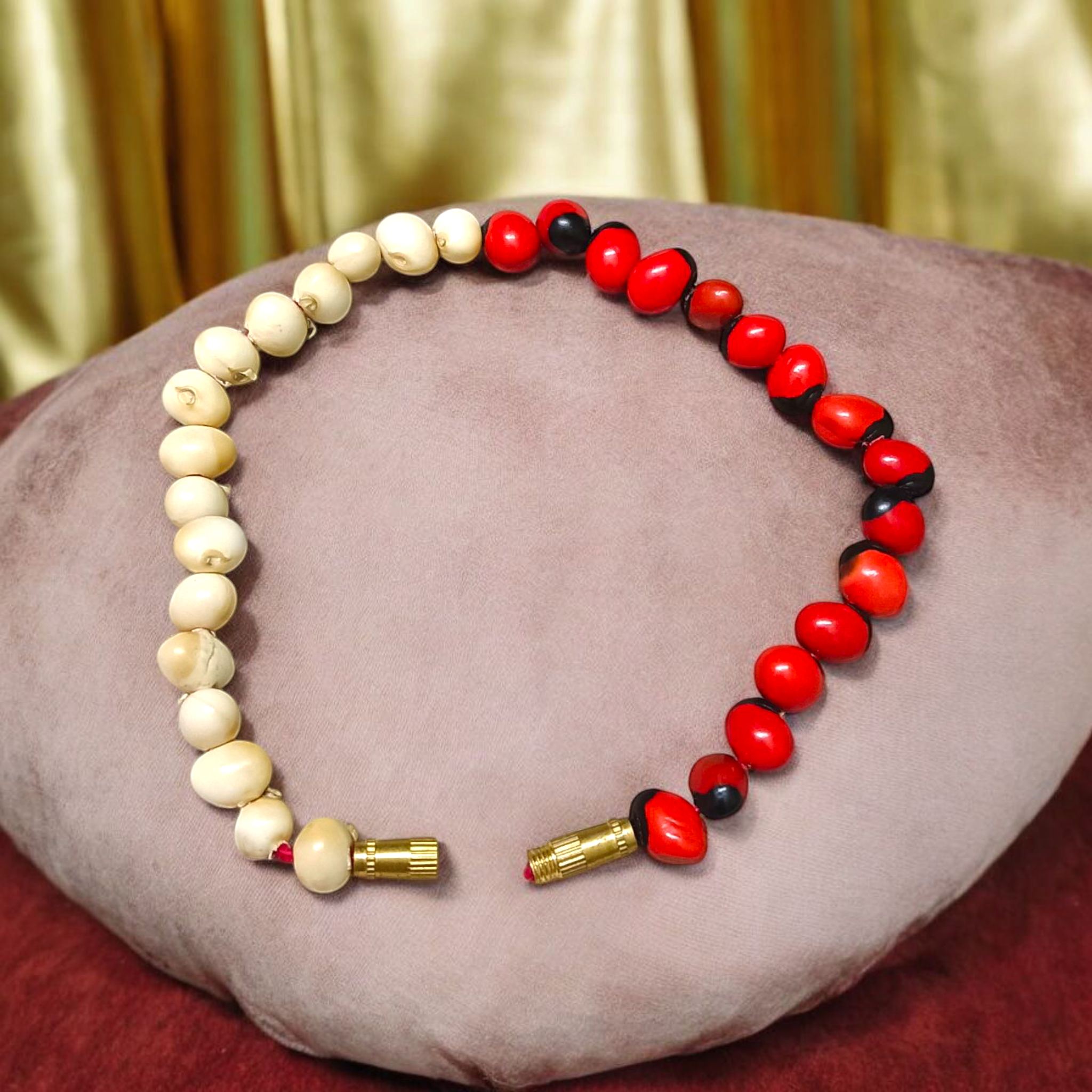 Natural Red and White Gunja seed bracelet with 5mm stretchable beads, spiritual design laid on a neutral background