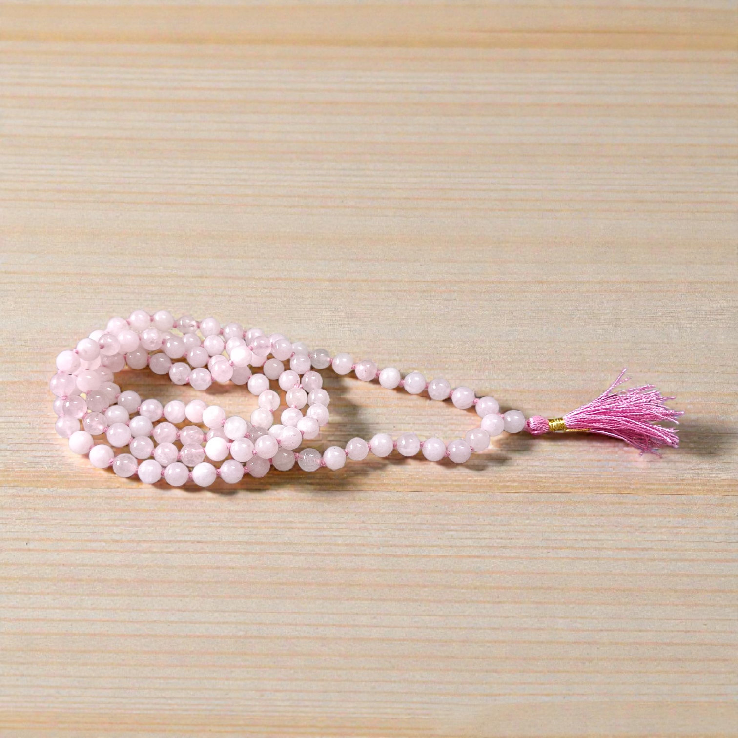 Natural Rose Quartz Mala with 8mm pink beads arranged neatly for meditation and spiritual use