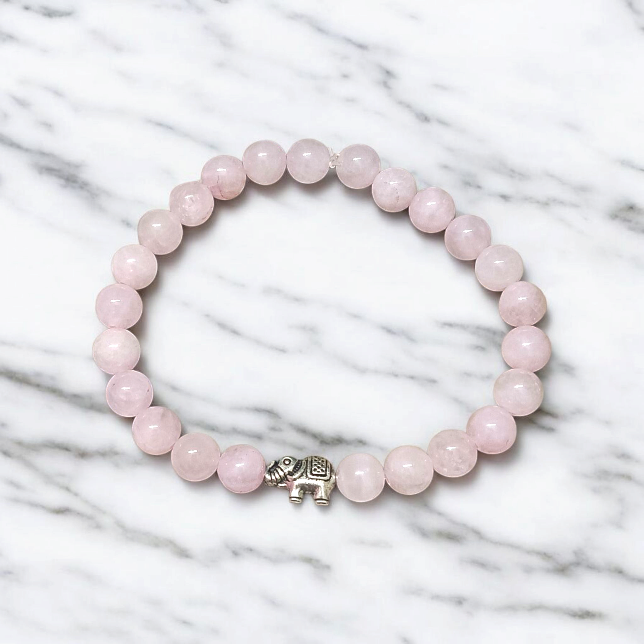Natural Rose Quartz bracelet with 8mm round pink beads on a stretchable band, displayed on a clean white background