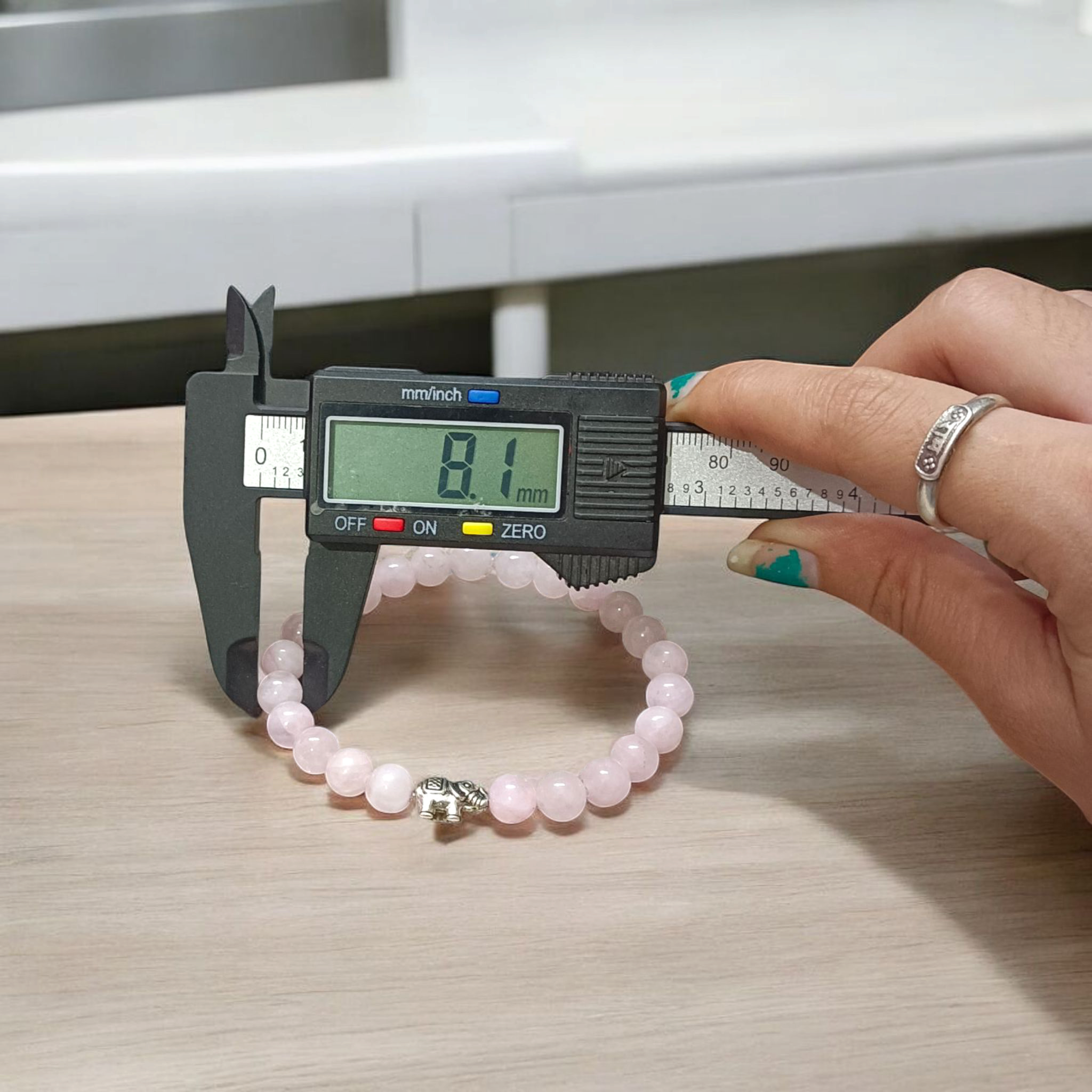 Natural Rose Quartz bracelet with 8mm round pink beads on a stretchable band, displayed on a clean white background