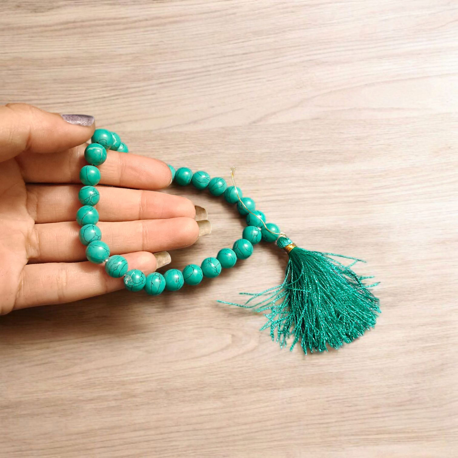 Natural Turquoise Mala with 8mm beads laid out on a wooden surface, showing two variants 27+1 and 108+1 beads.