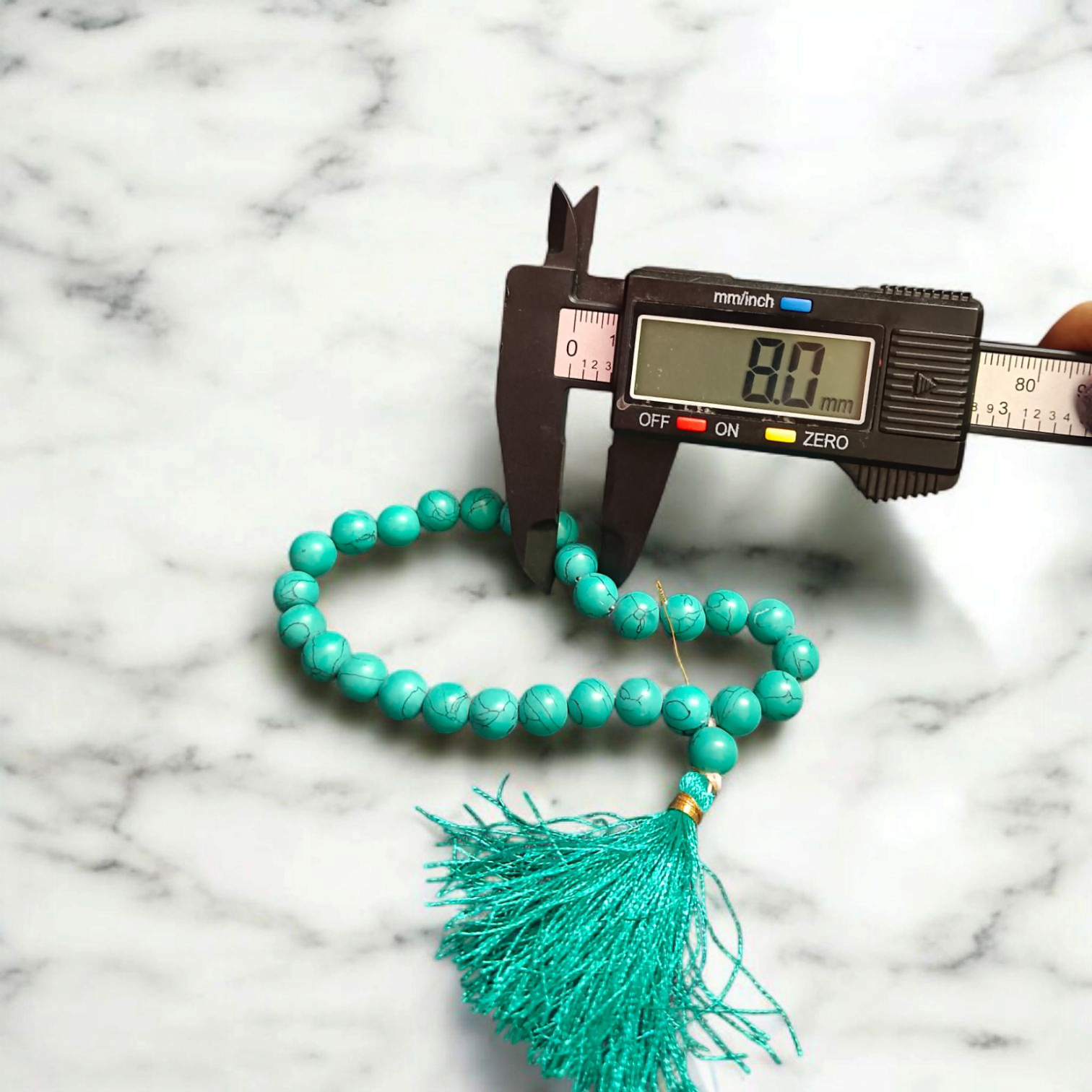 Natural Turquoise Mala with 8mm beads laid out on a wooden surface, showing two variants 27+1 and 108+1 beads.