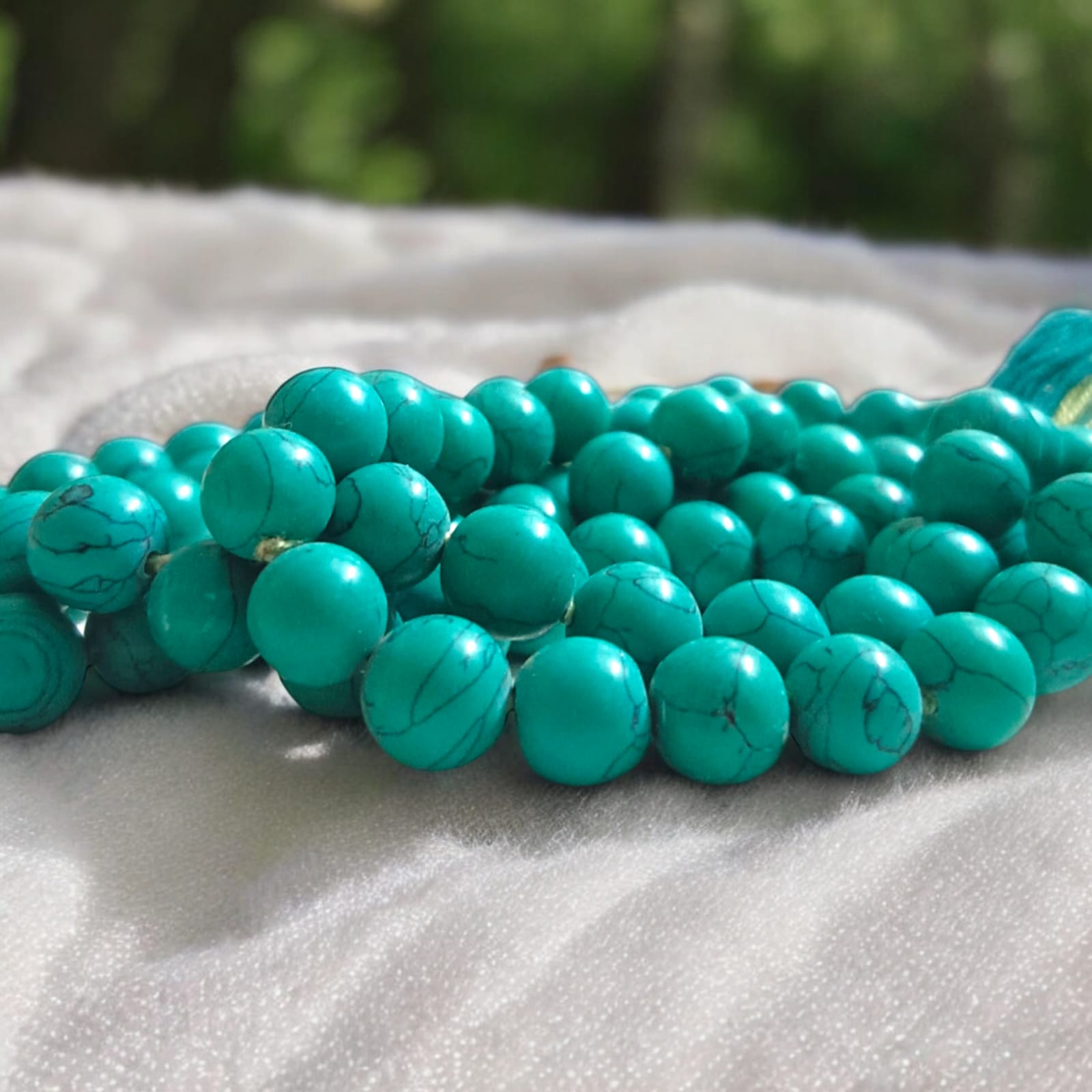 Natural Turquoise Mala with 8mm beads laid out on a wooden surface, showing two variants 27+1 and 108+1 beads.