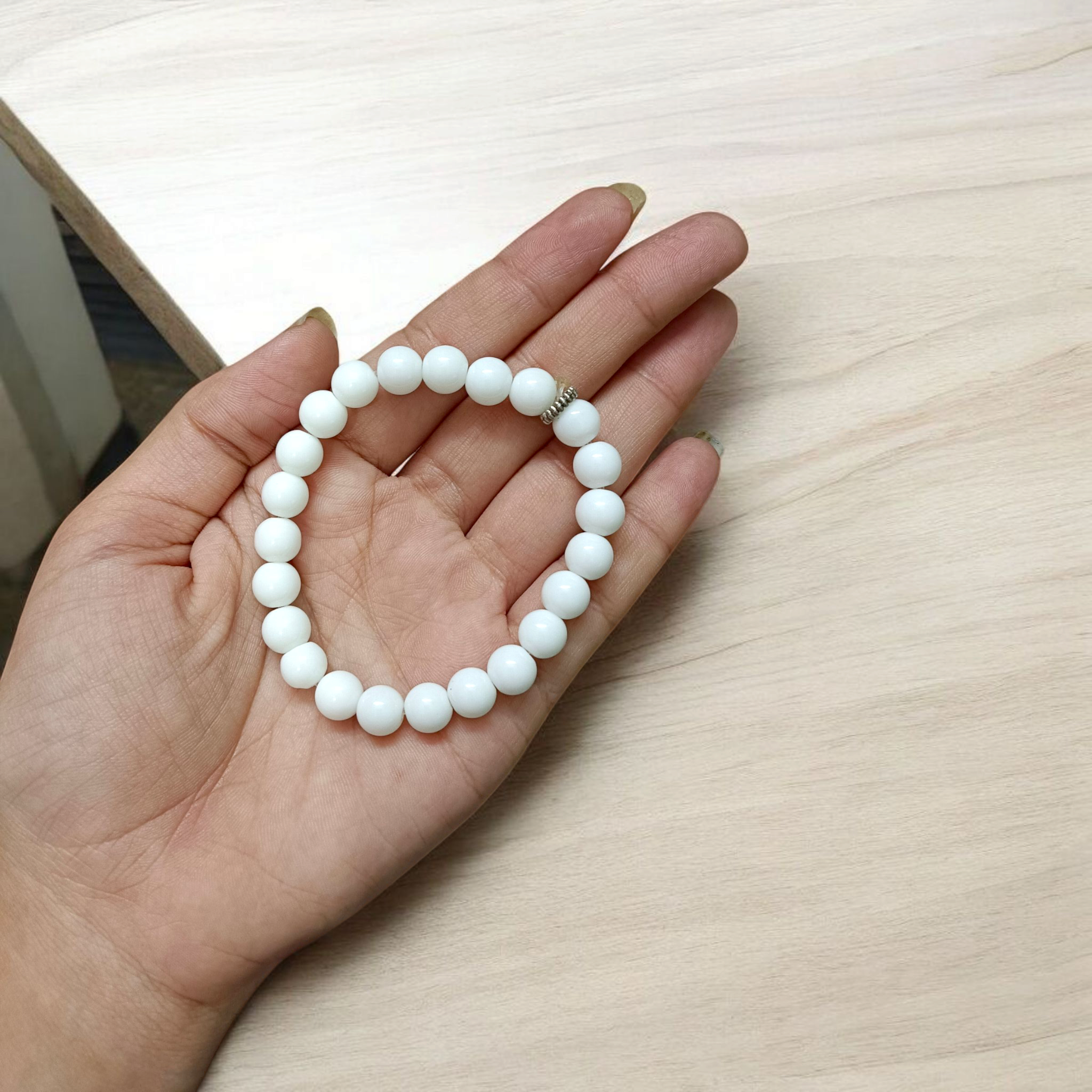 Natural White Agate bracelet with polished 8mm beads on a stretchable cord, displayed on a plain white background