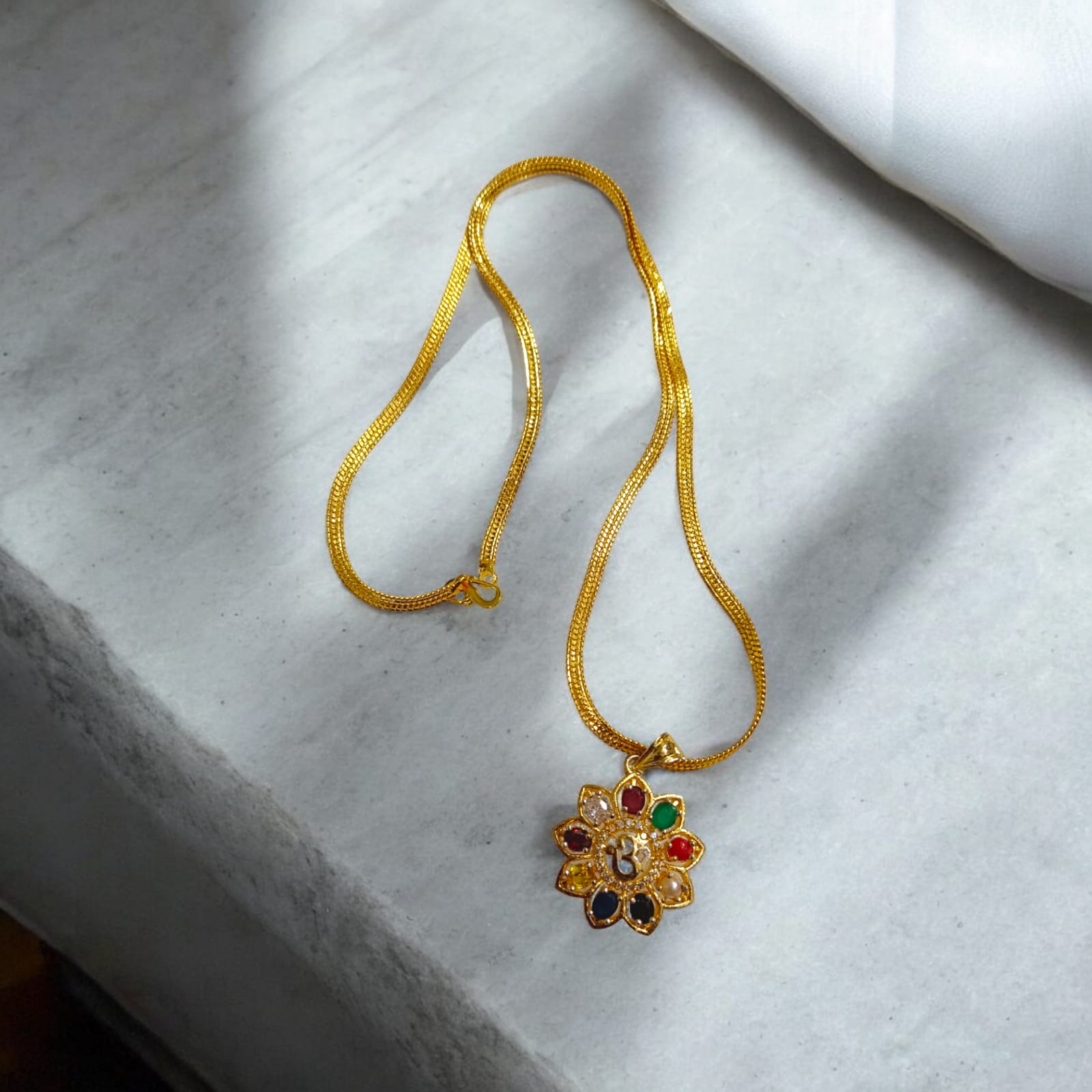 Navratan Locket with Om symbol and nine gemstones, including a free gold-plated chain for spiritual and astrological benefits.