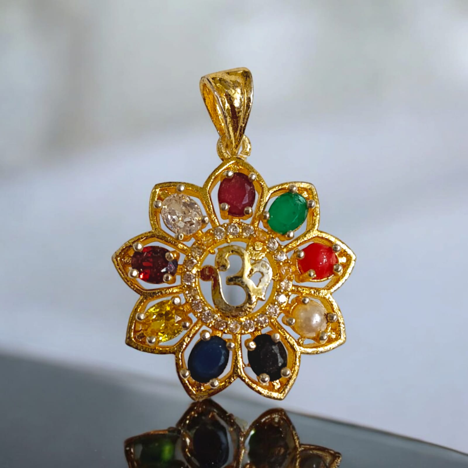 Navratan Locket with Om symbol and nine gemstones, including a free gold-plated chain for spiritual and astrological benefits.
