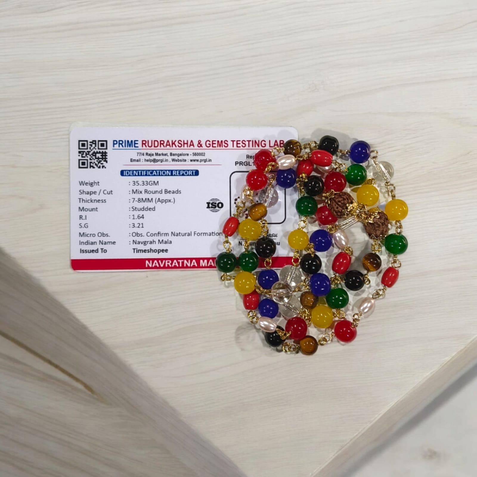 Navratna Mala with Rudraksh beads, featuring lab-certified gemstones for astrological balance and spiritual enhancement.