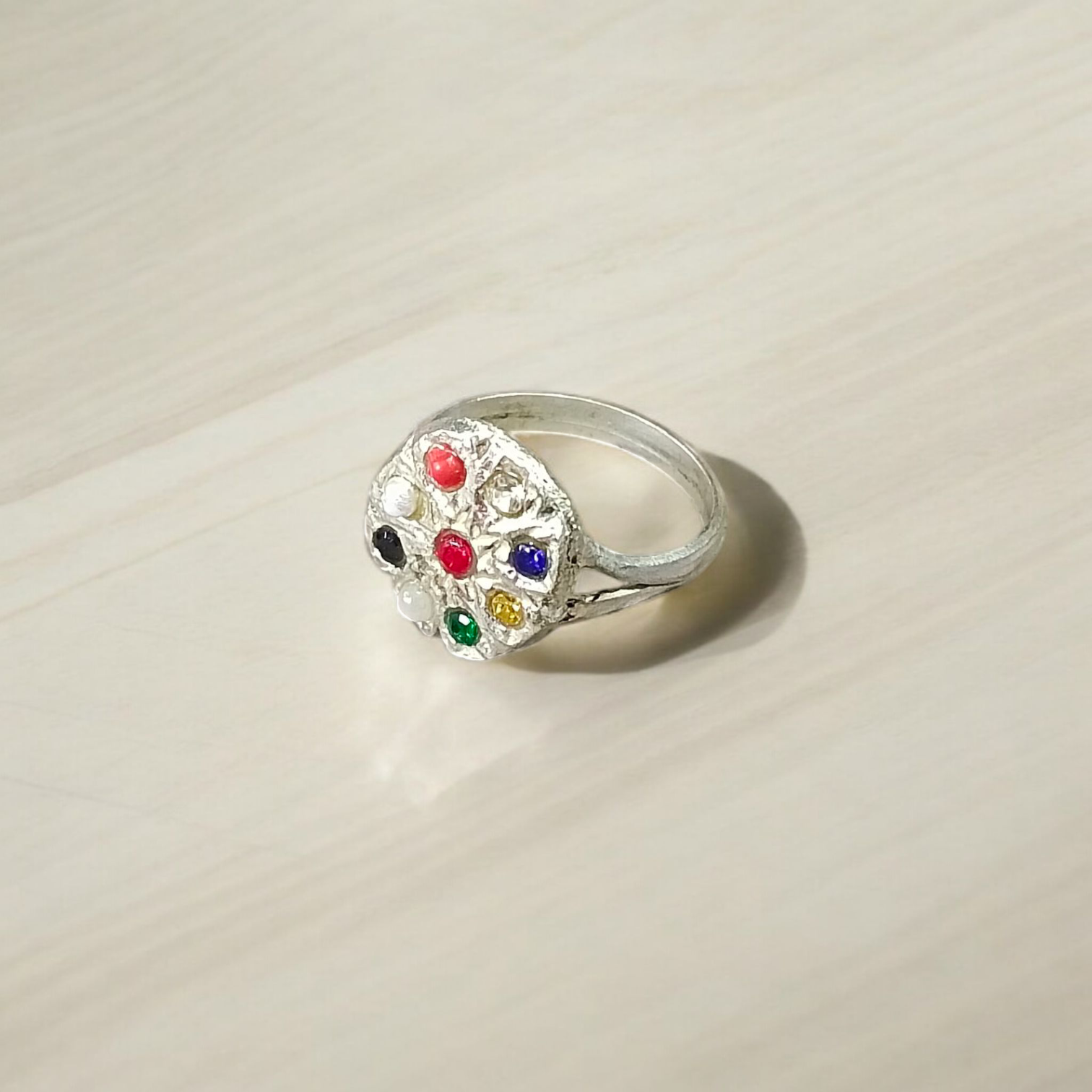 Oval-shaped Navratan Ring with silver plating, featuring nine gemstones for astrological balance and spiritual