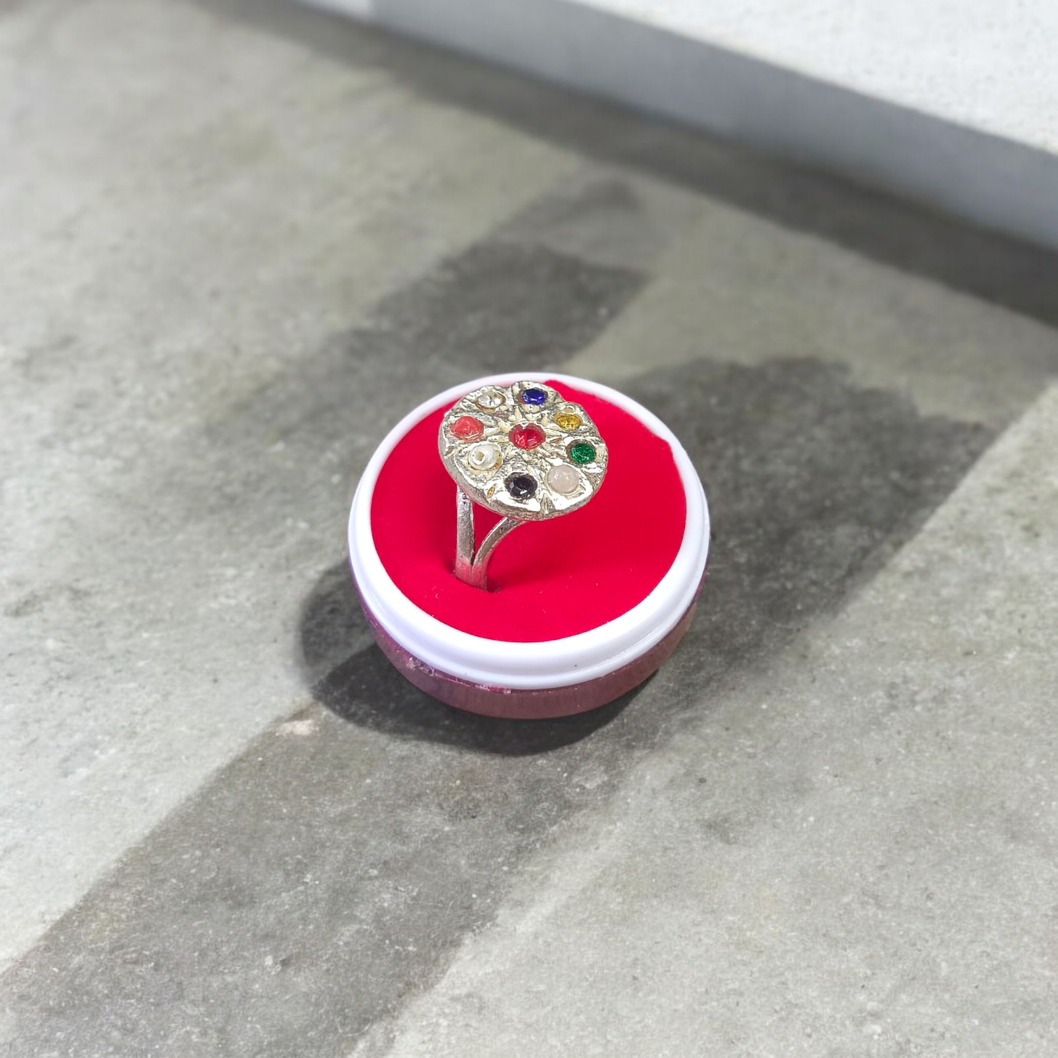 Oval-shaped Navratan Ring with silver plating, featuring nine gemstones for astrological balance and spiritual