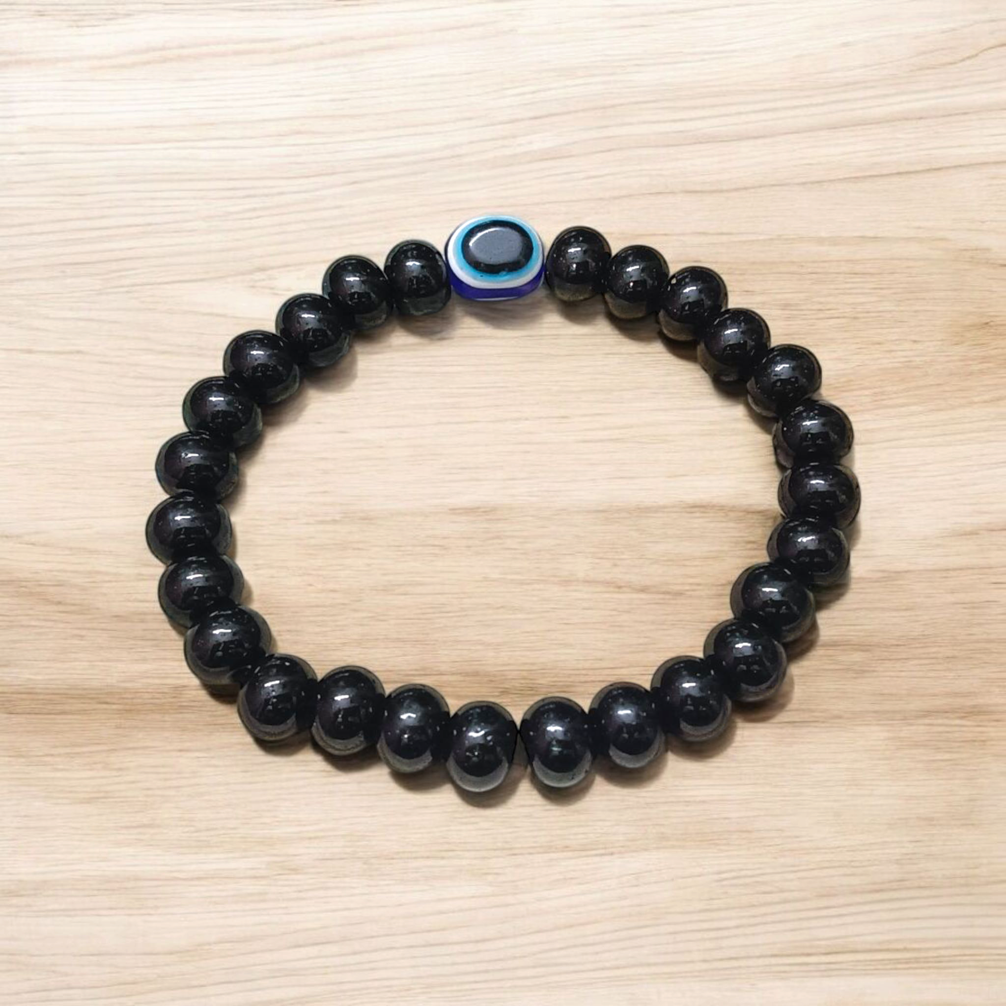 Stretchable Black Obsidian Bracelet made with natural 8mm beads, placed on a light background, highlighting its glossy finish