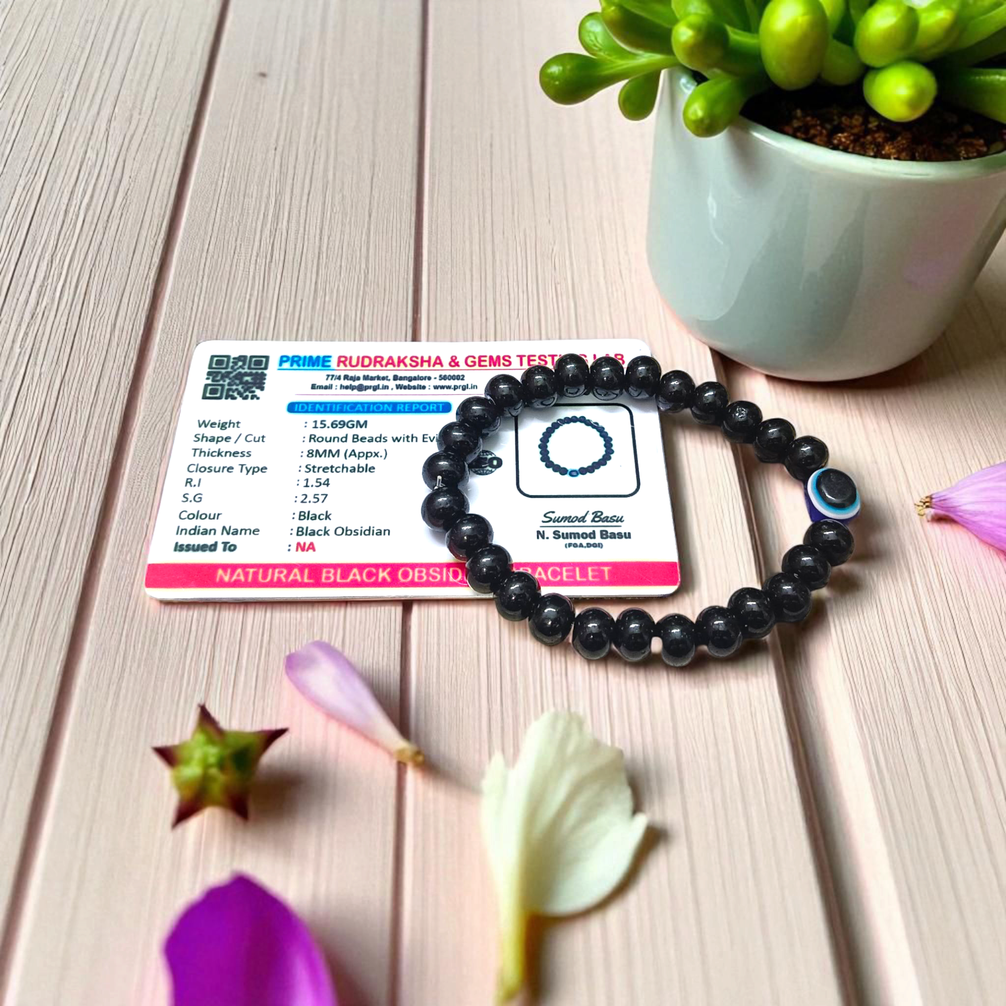 Stretchable Black Obsidian Bracelet made with natural 8mm beads, placed on a light background, highlighting its glossy finish
