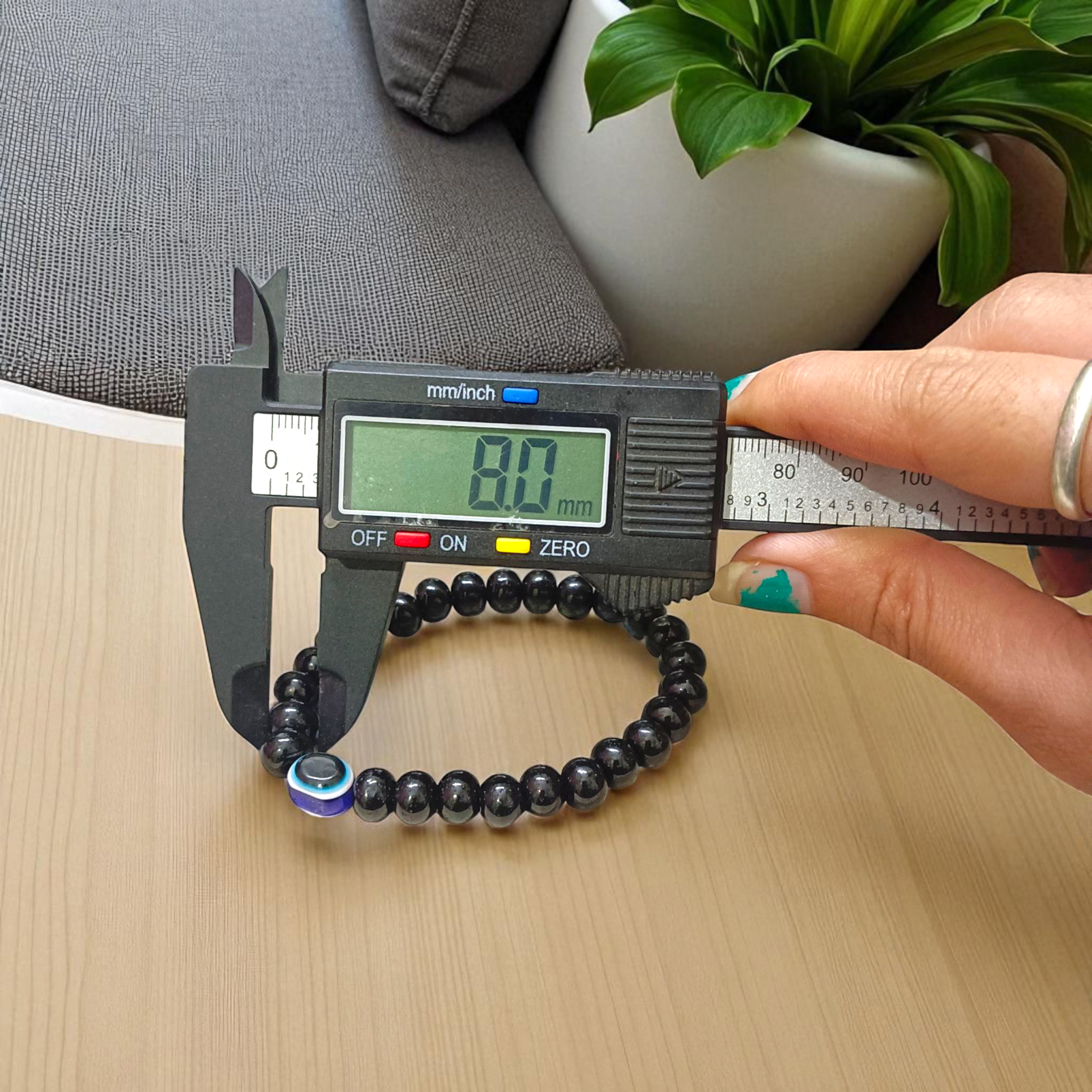 Stretchable Black Obsidian Bracelet made with natural 8mm beads, placed on a light background, highlighting its glossy finish