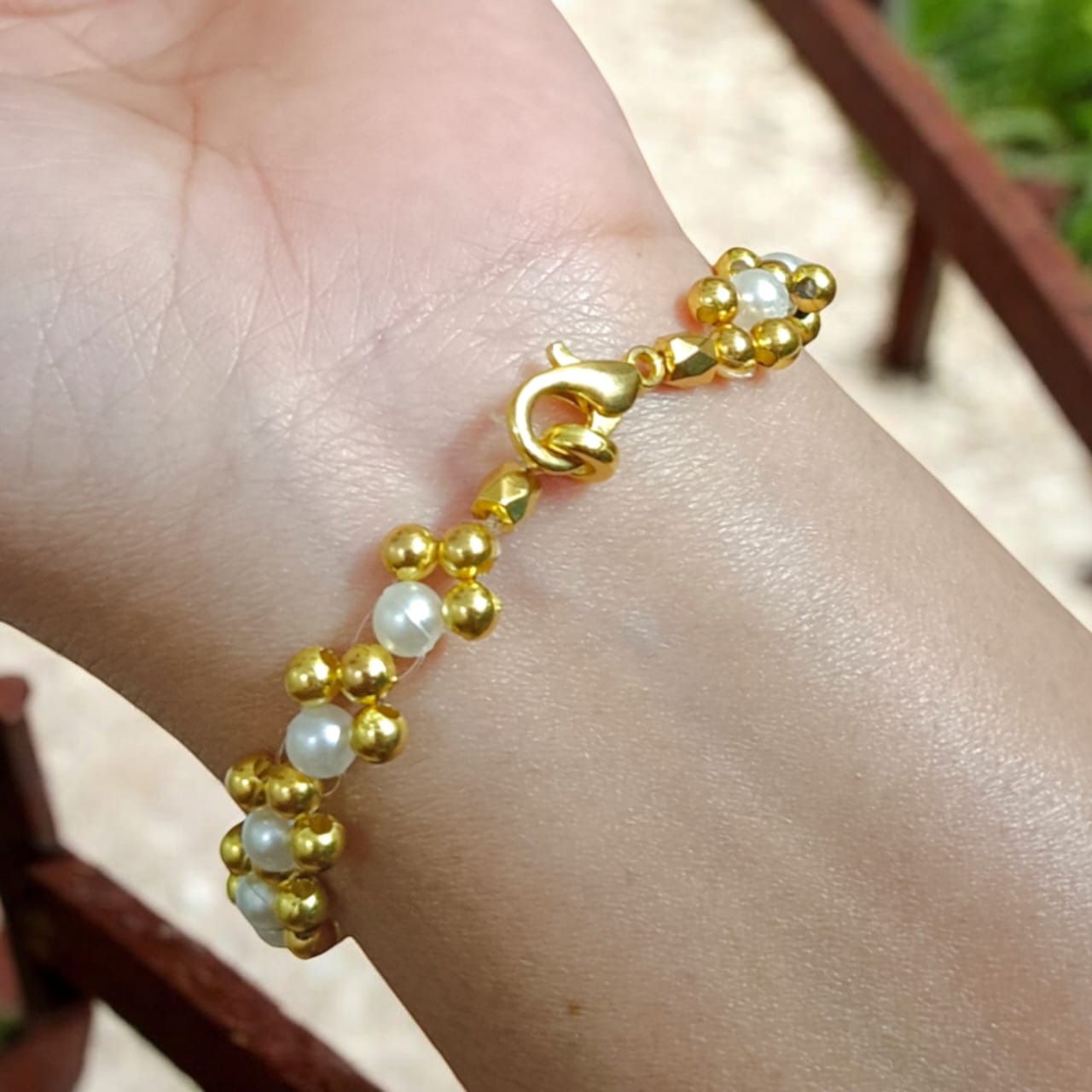 White and golden pearl bead bracelet with a lobster clasp, designed for girls and women, perfect for matching with golden and white outfits.