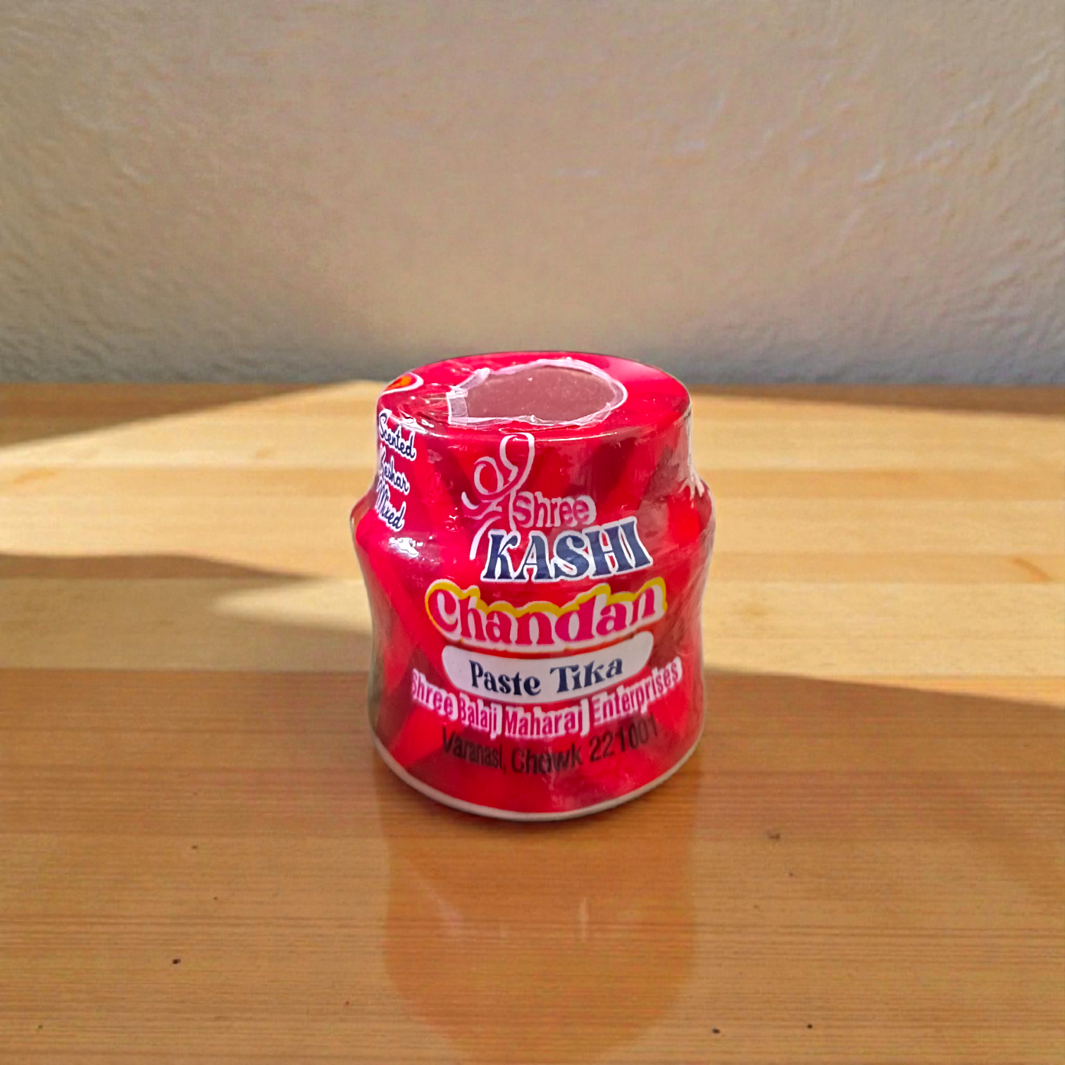 Yellow, red, and white chandan paste containers used for tilak and puja