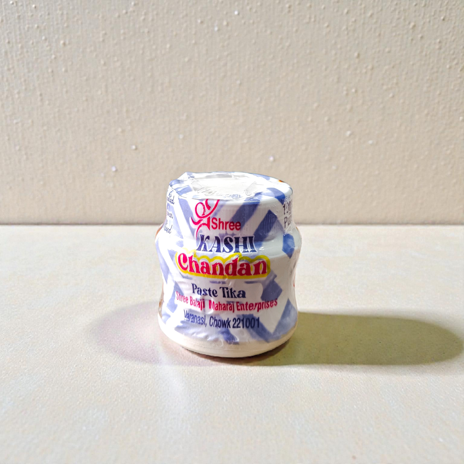 Yellow, red, and white chandan paste containers used for tilak and puja