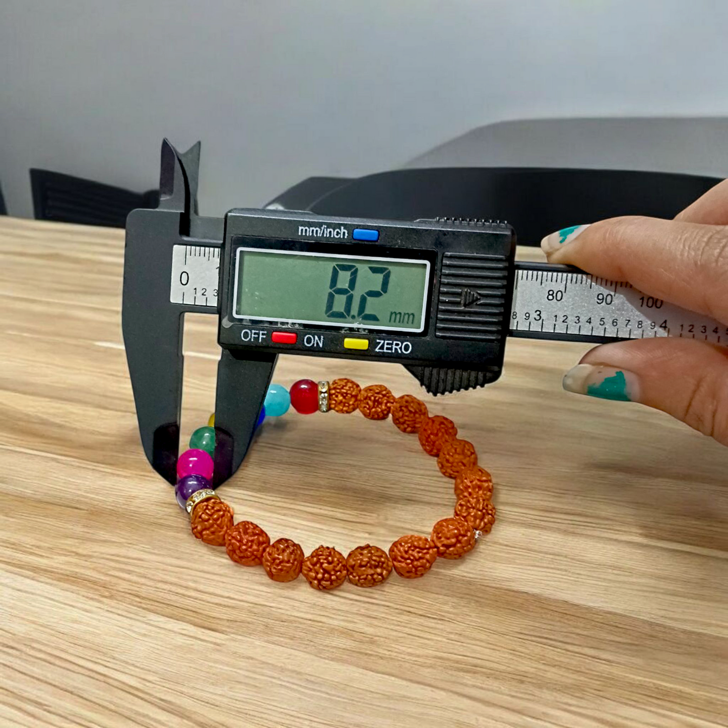 7 Chakra & Rudraksha Bracelet with 8mm natural beads, arranged in colorful chakra order alongside sacred Rudraksha beads, displayed on a spiritual setting