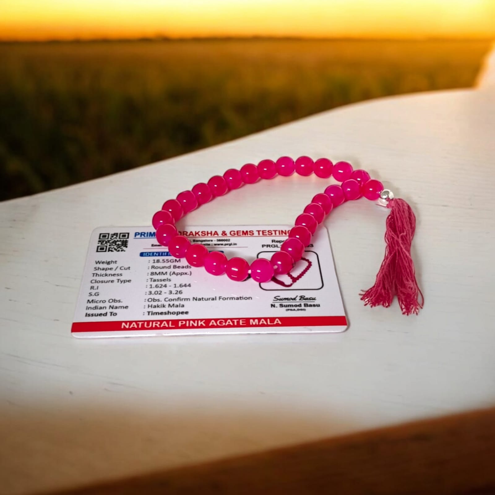 A 27+1 bead pink agate mala, each bead measuring 8mm, shown with its lab certification. Ideal for meditation, wearing, or enhancing positive energy in car and office.