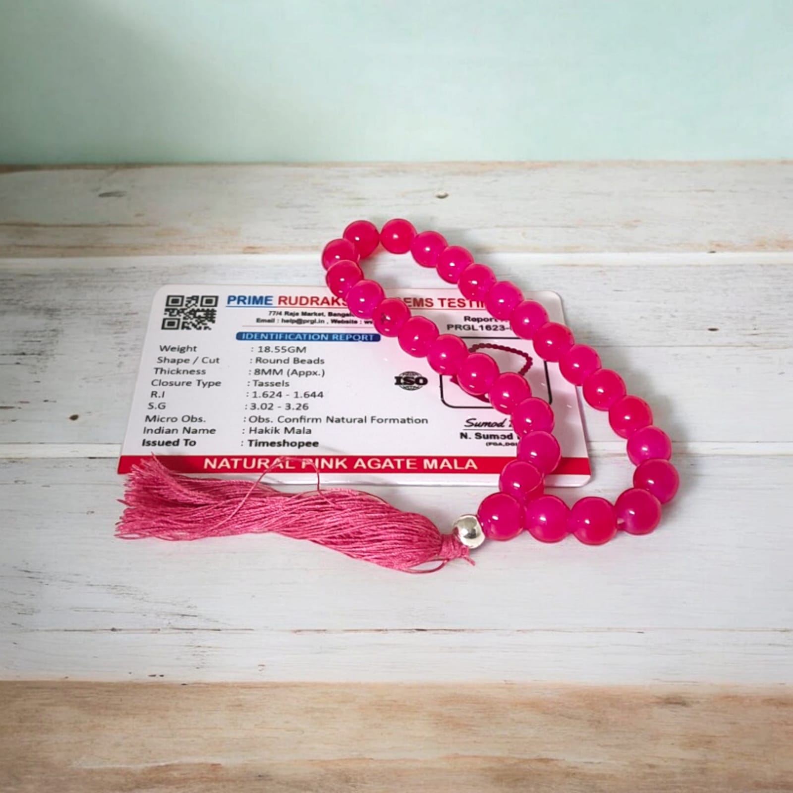 A 27+1 bead pink agate mala, each bead measuring 8mm, shown with its lab certification. Ideal for meditation, wearing, or enhancing positive energy in car and office.