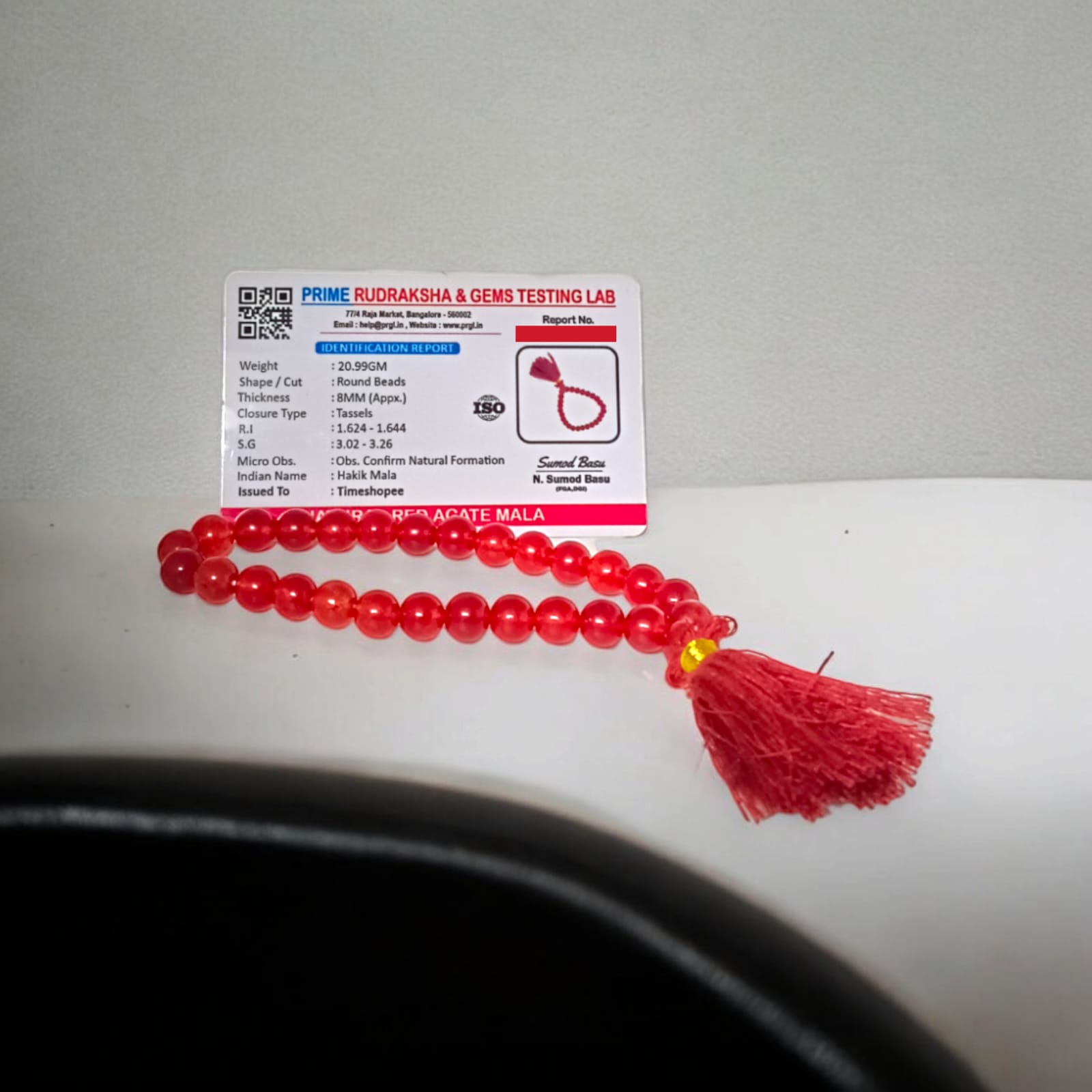 A 27+1 bead red agate mala, each bead measuring 8mm, shown with its lab certification. Ideal for meditation, wearing, or keeping in cars and offices.