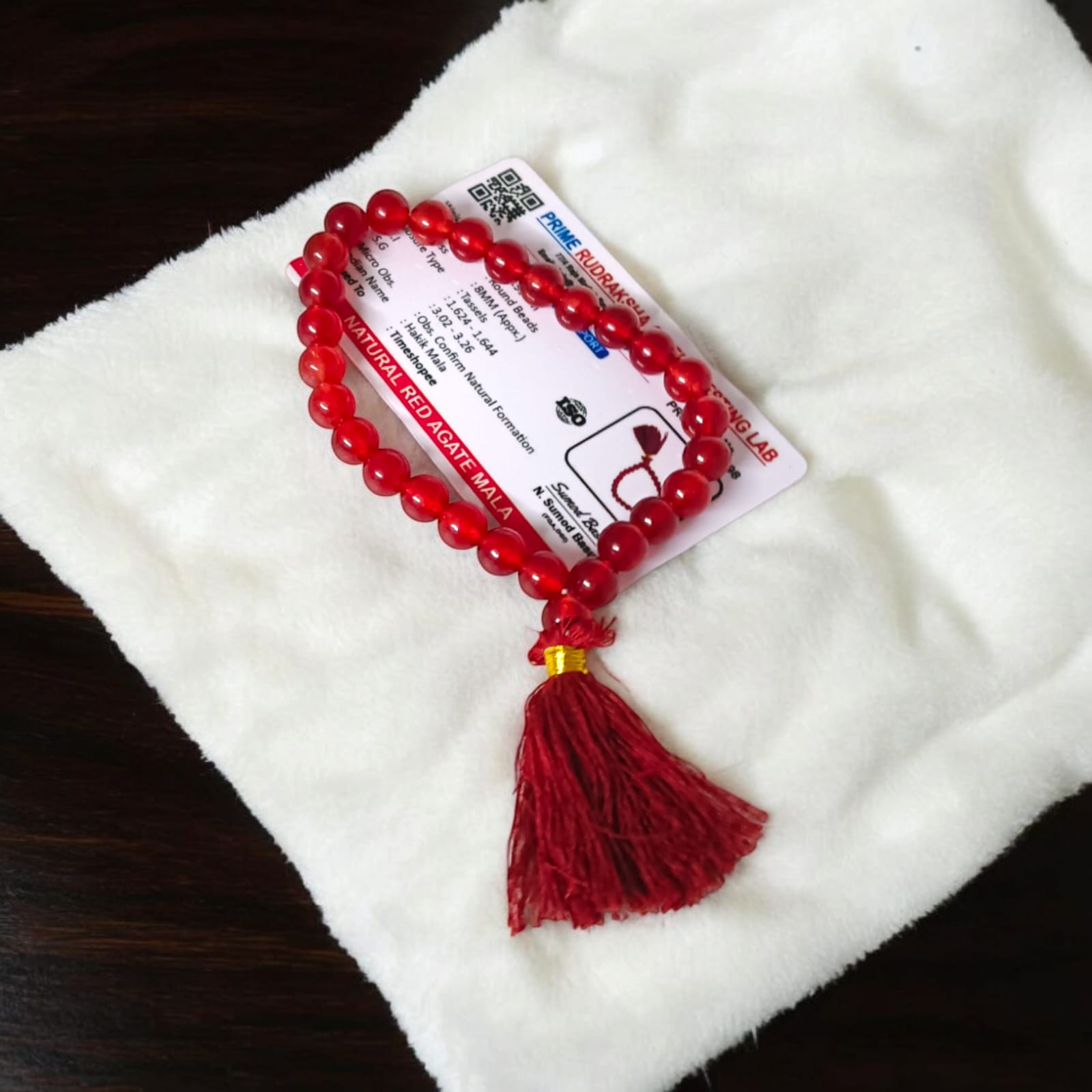A 27+1 bead red agate mala, each bead measuring 8mm, shown with its lab certification. Ideal for meditation, wearing, or keeping in cars and offices.