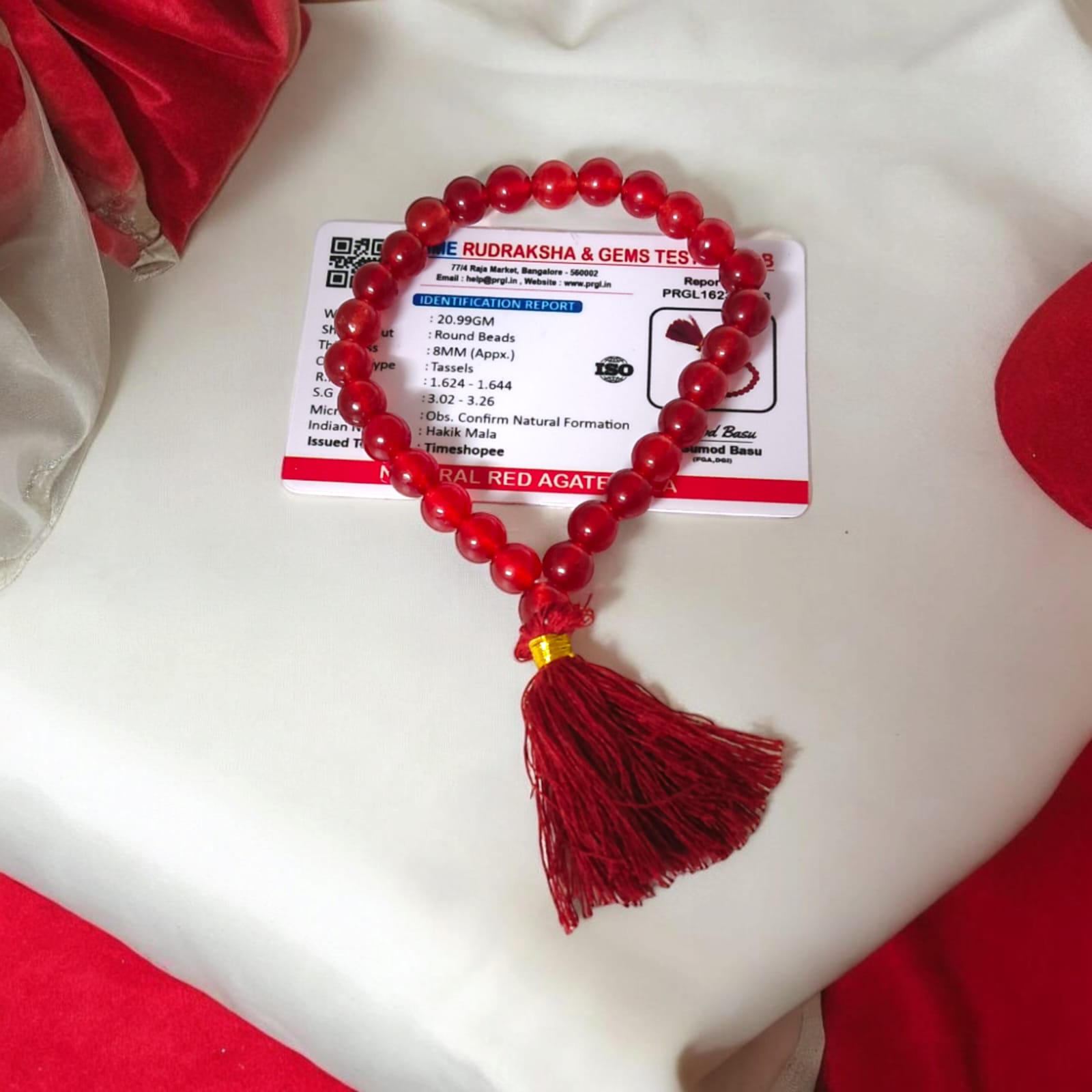 A 27+1 bead red agate mala, each bead measuring 8mm, shown with its lab certification. Ideal for meditation, wearing, or keeping in cars and offices.