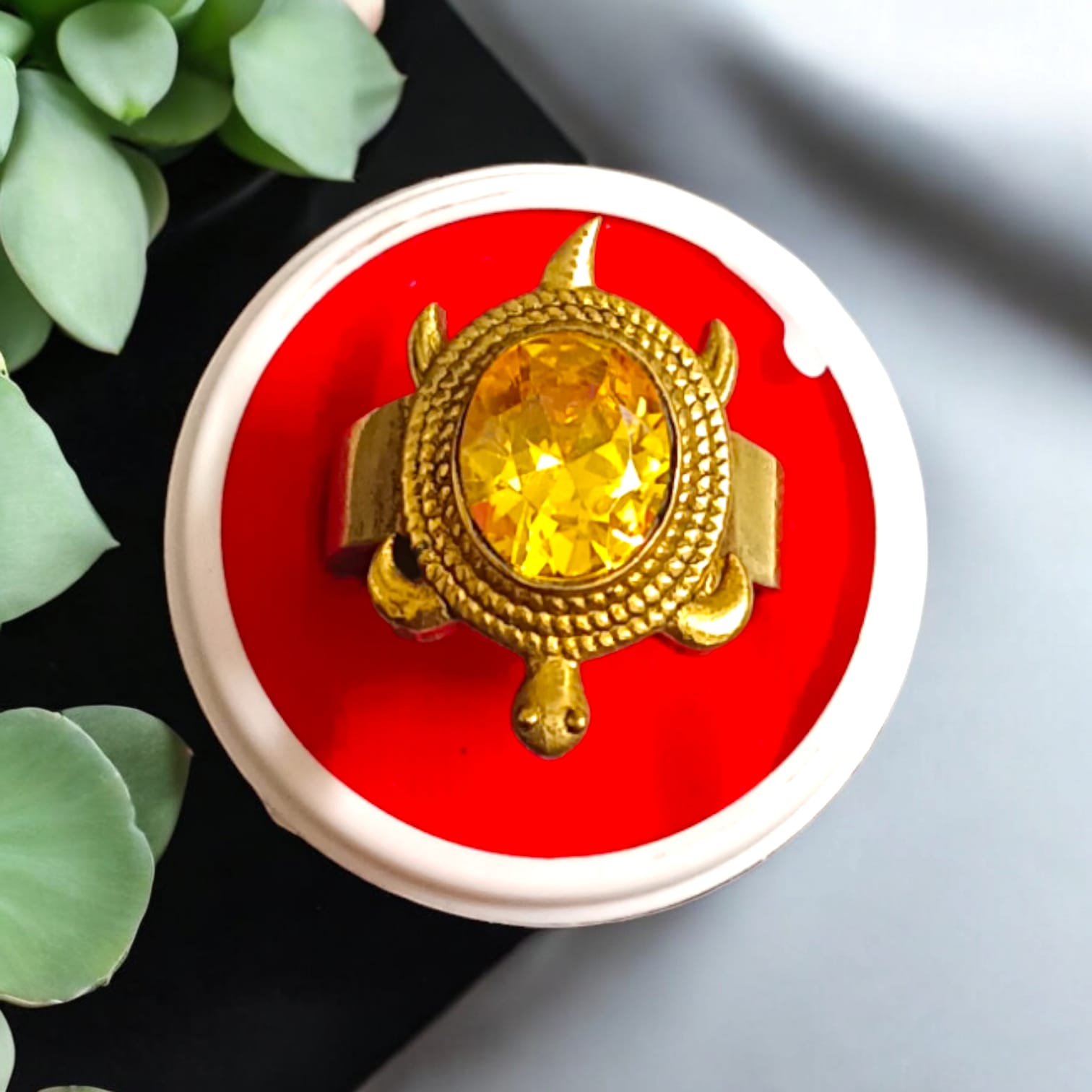 A close-up of the Kachua Pukhraj Ring, featuring a bright yellow Pukhraj (Yellow Sapphire) gemstone set in a tortoise-shaped design made from Ashtdhatu. The ring is adjustable and suitable for both men and women.