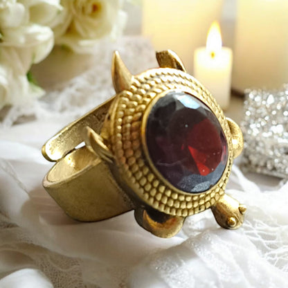 A close-up view of the Kachua Manik Ring, featuring a vibrant red Manik (Ruby) gemstone set in a tortoise-shaped design made from Ashtdhatu. The ring is adjustable and suitable for both men and women.