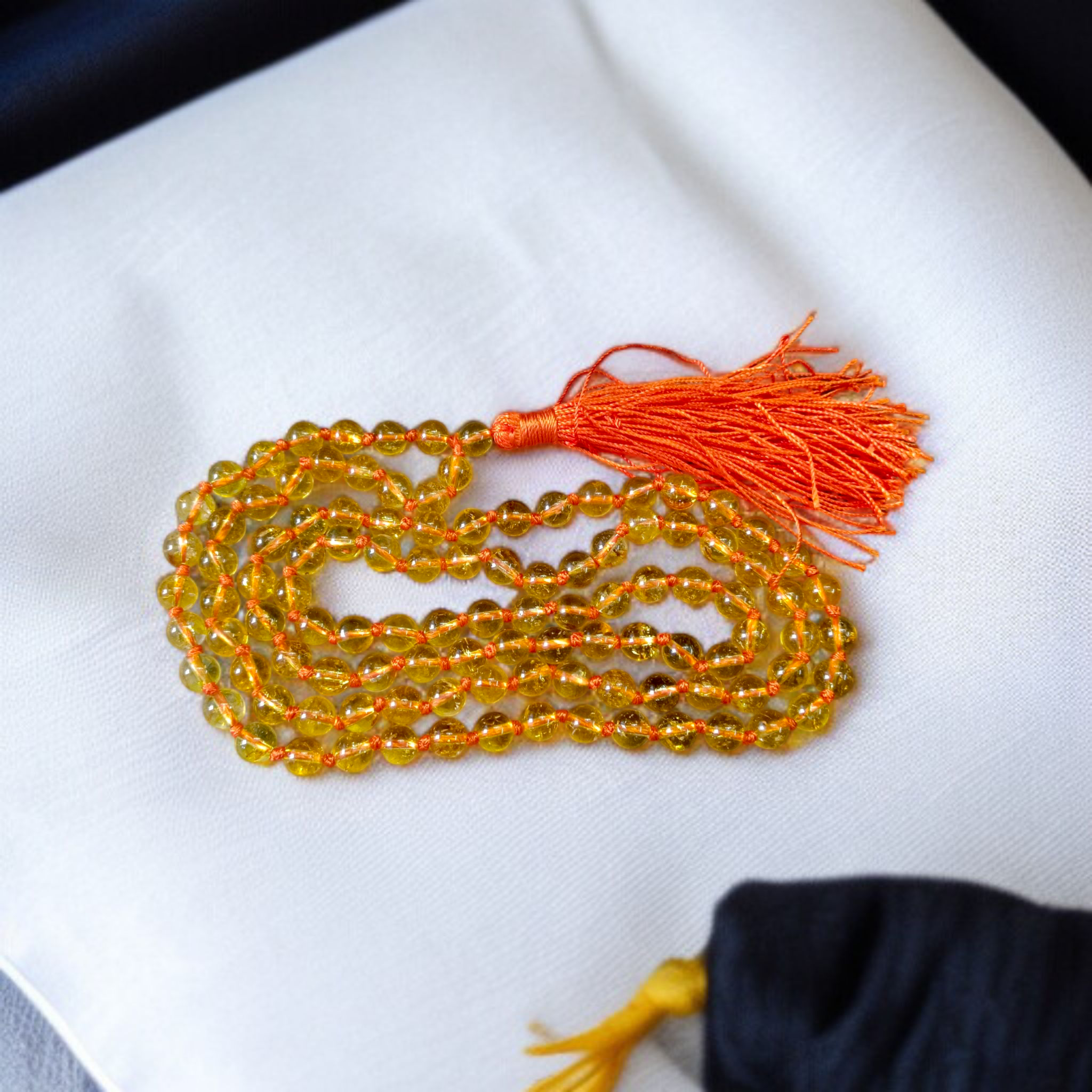 A handcrafted Citrine Mala made of 108+1 golden-yellow 8mm beads, used for meditation, energy healing, and Japa, displayed on a wooden background