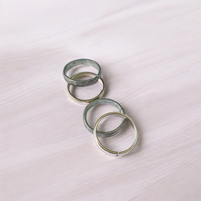 A set of four Ghode Ki Naal ka Challa rings made from black horse shoe nails, each ring designed to mitigate the negative effects of Saturn (Shani). The rings are shown in a close-up view to highlight their craftsmanship and material